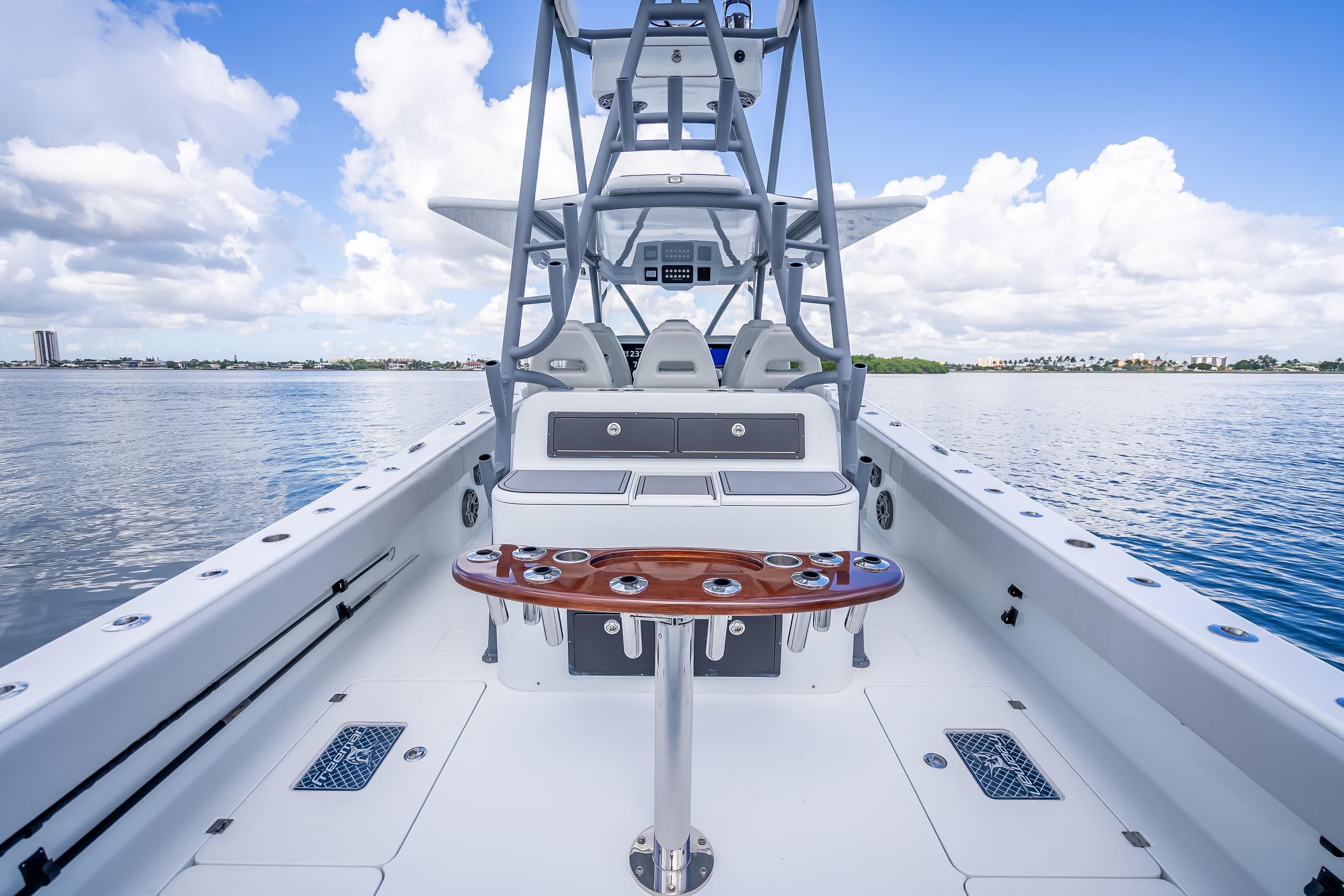 2020 Freeman 42LR boat interior with fishing rod holders, on calm water under blue sky.