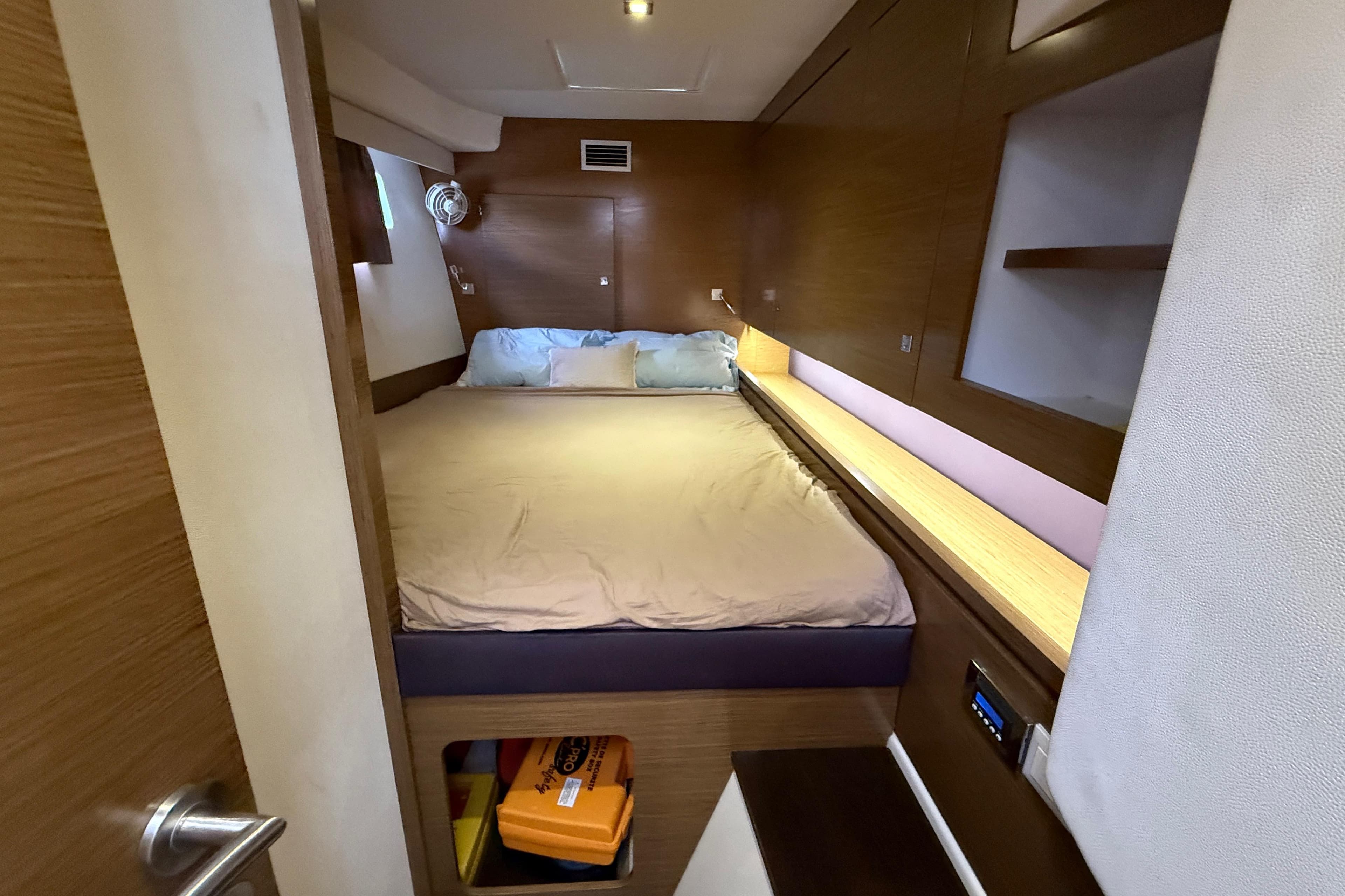 Cozy cabin interior of 2015 Fountaine Pajot Summerland 40 LC with wooden accents and bed.