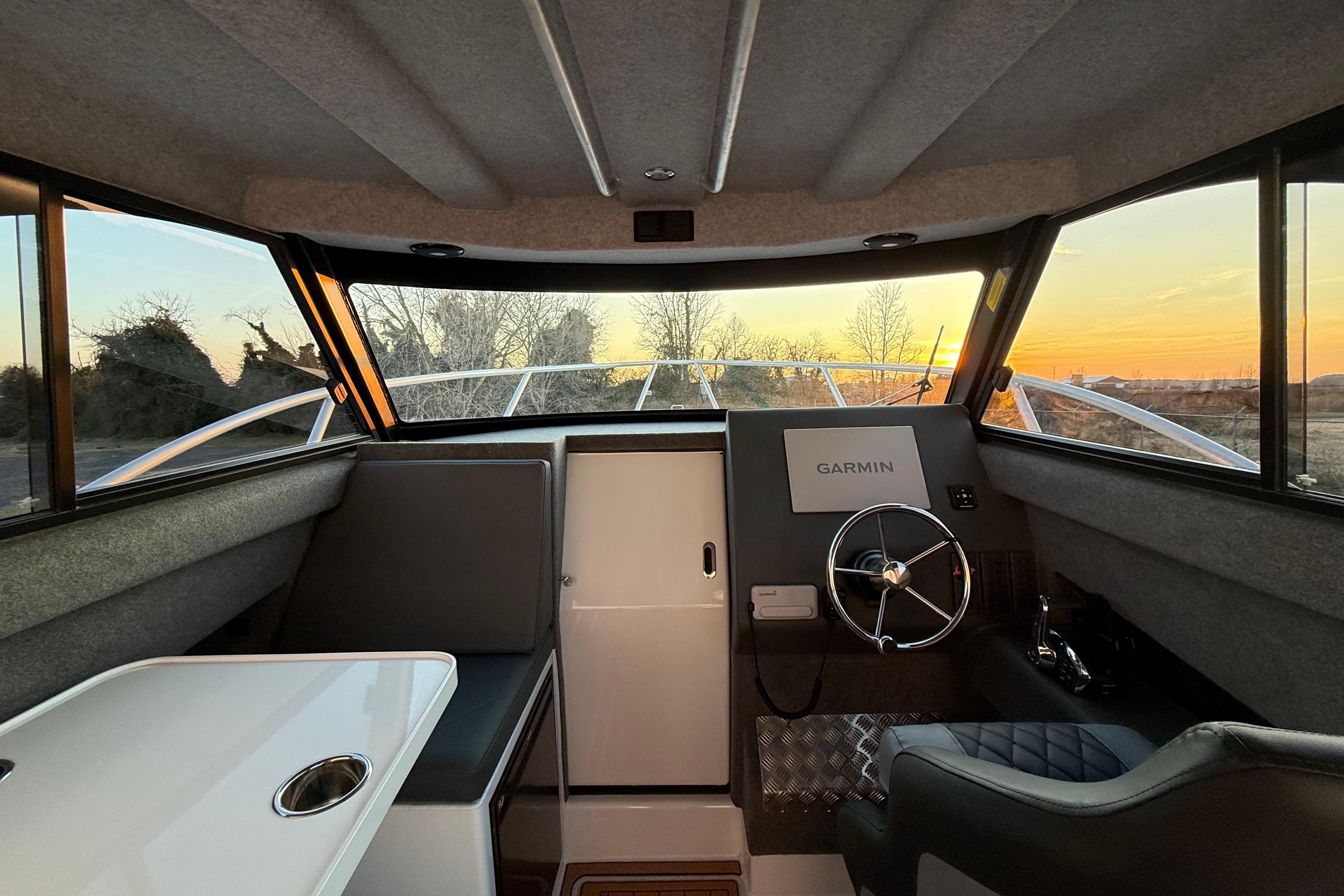 Interior of 2026 Makaira Gen3 26 Outboard boat with Garmin navigation system at sunset.