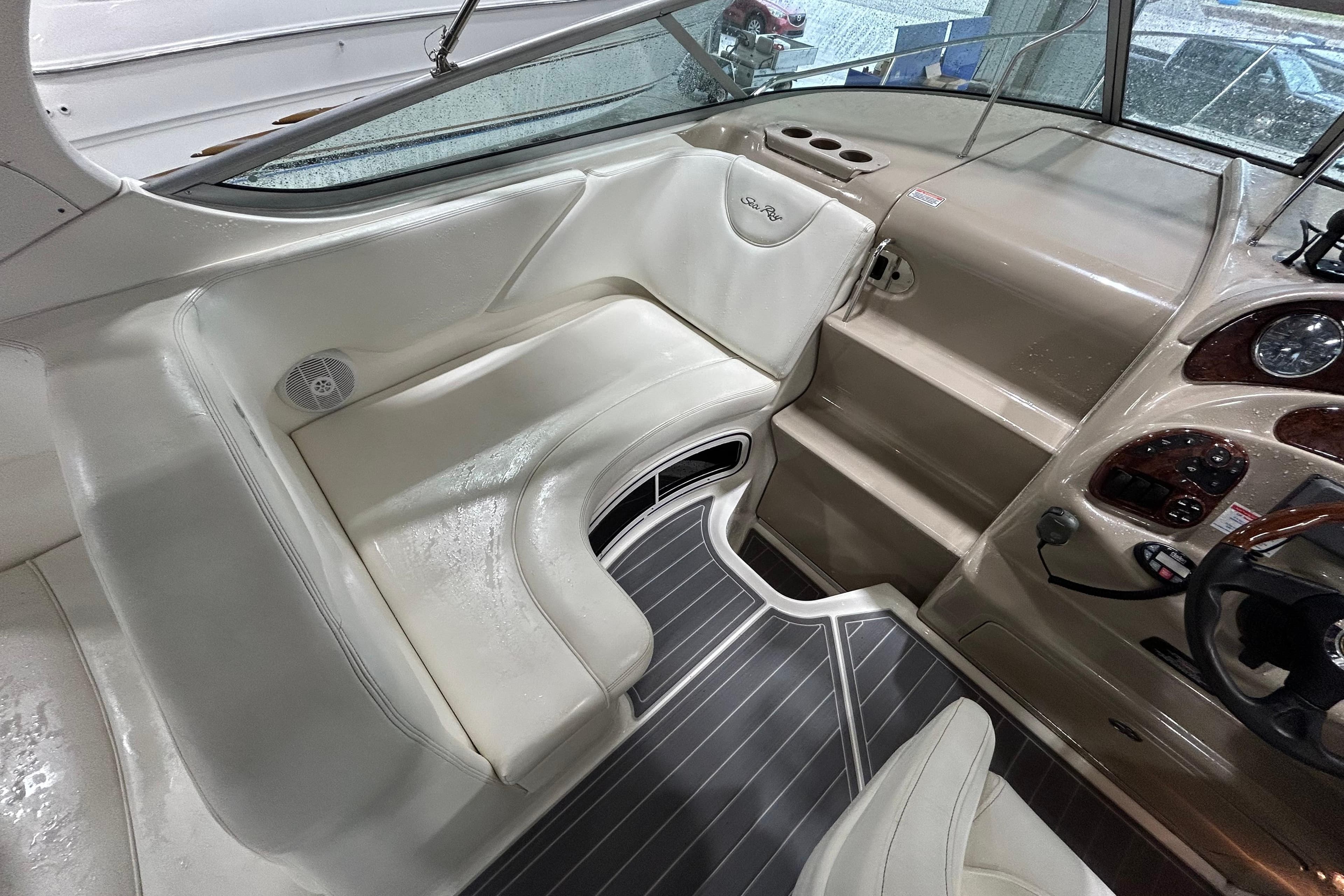 2004 Sea Ray Sundancer 280 cockpit with beige seating and sleek dashboard design.
