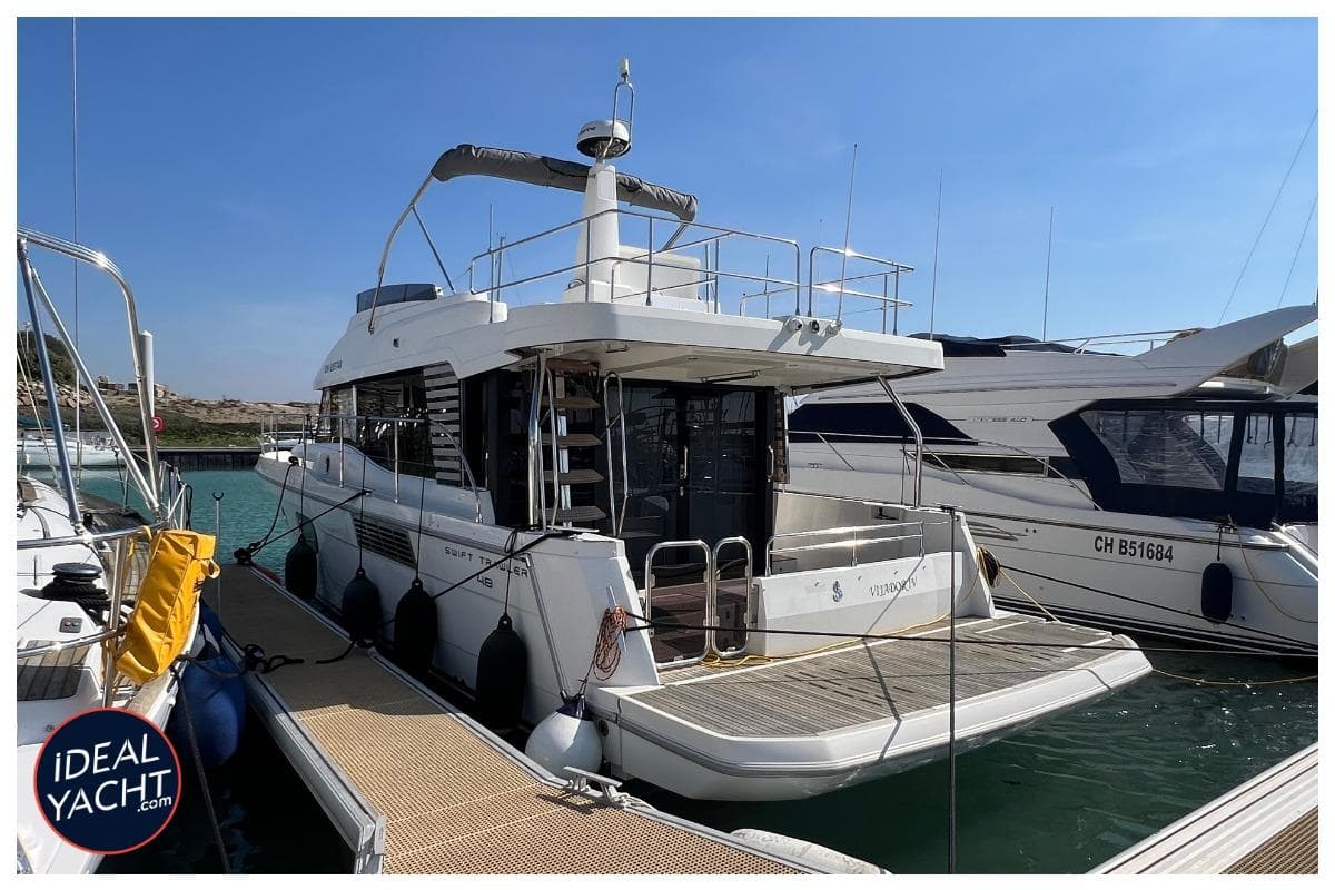 2023 Beneteau Swift Trawler 48 docked at marina, rear view.