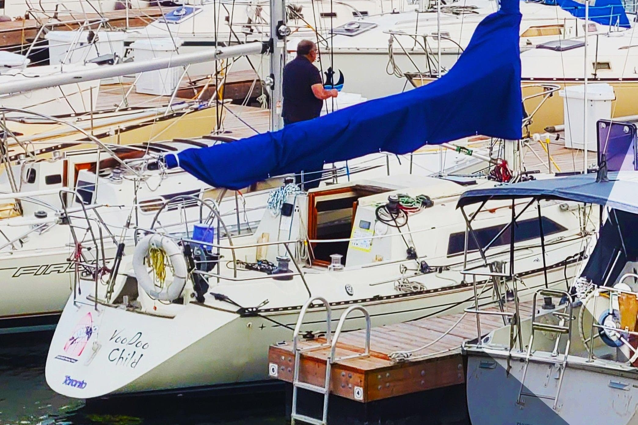Sailboat docked at marina, C&C 33 MK II, 1985 model, with blue sail cover.