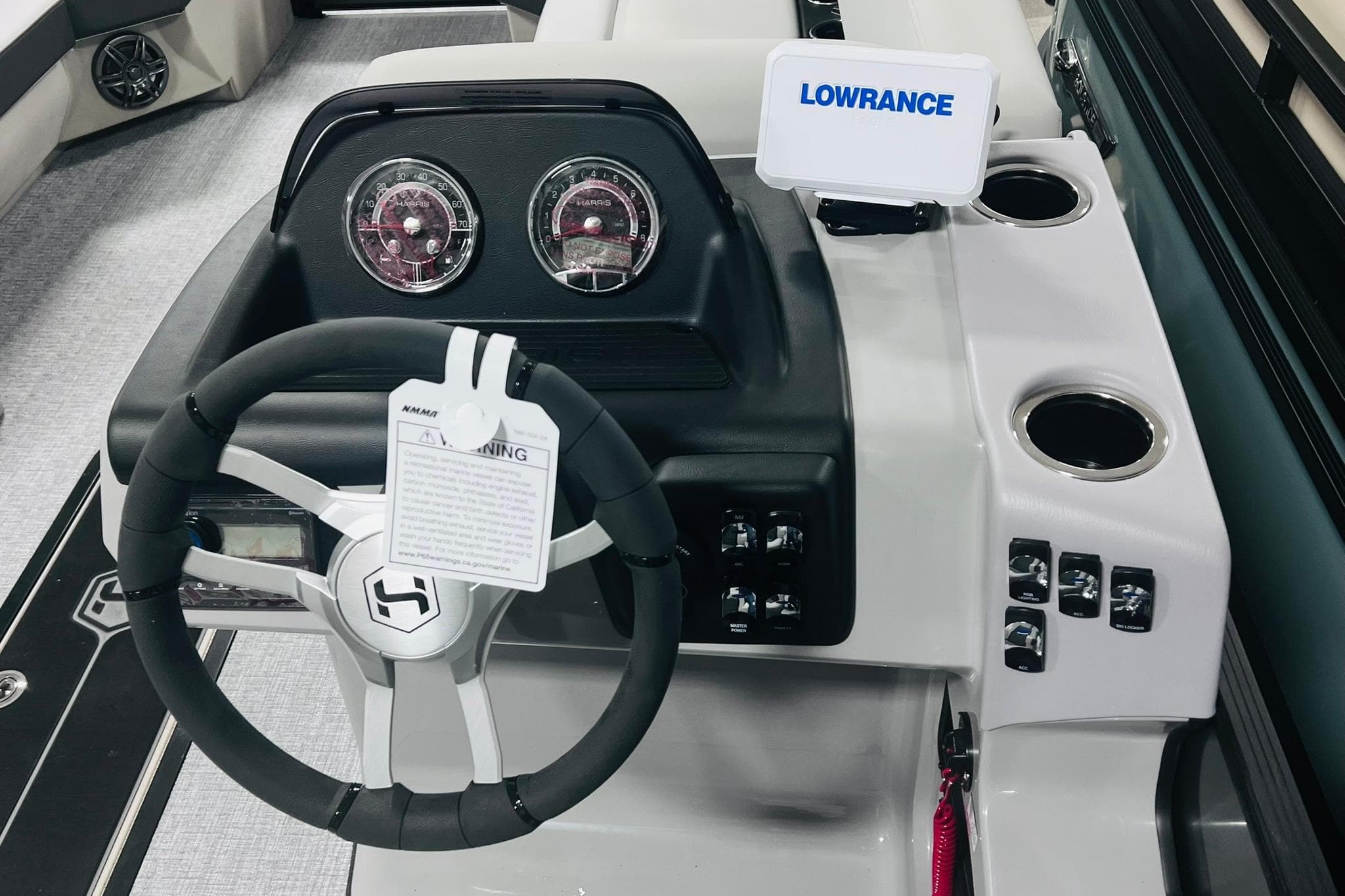 Steering console of 2025 Harris Cruiser 230 with Lowrance display and control panel.