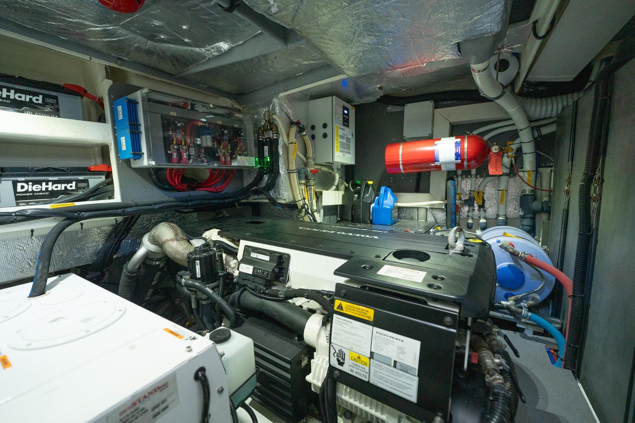 Engine room of a 2020 Absolute 50 Fly yacht, featuring batteries and fire extinguisher.