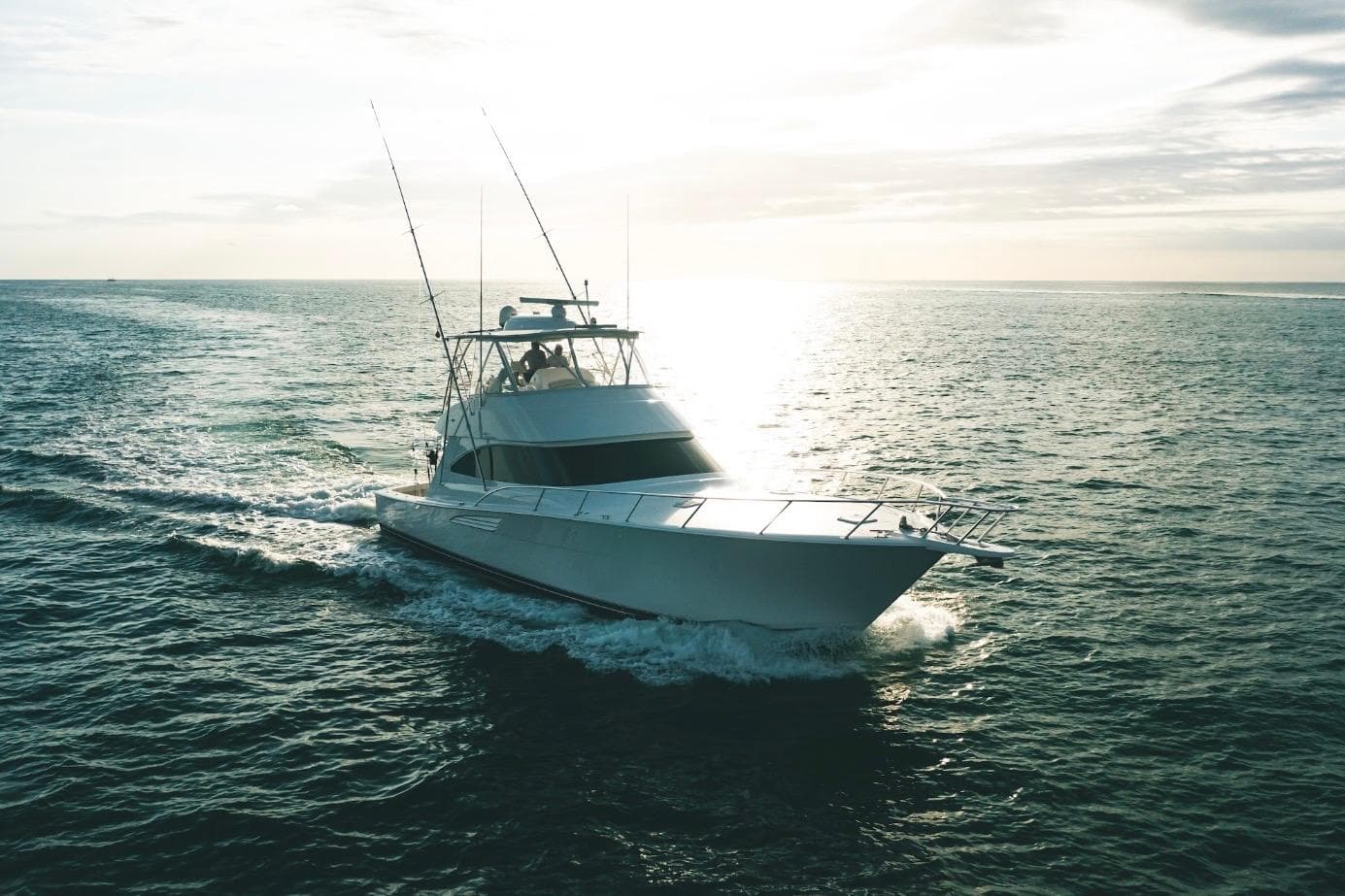 2021 Viking 58 Convertible yacht cruising on open water at sunset.