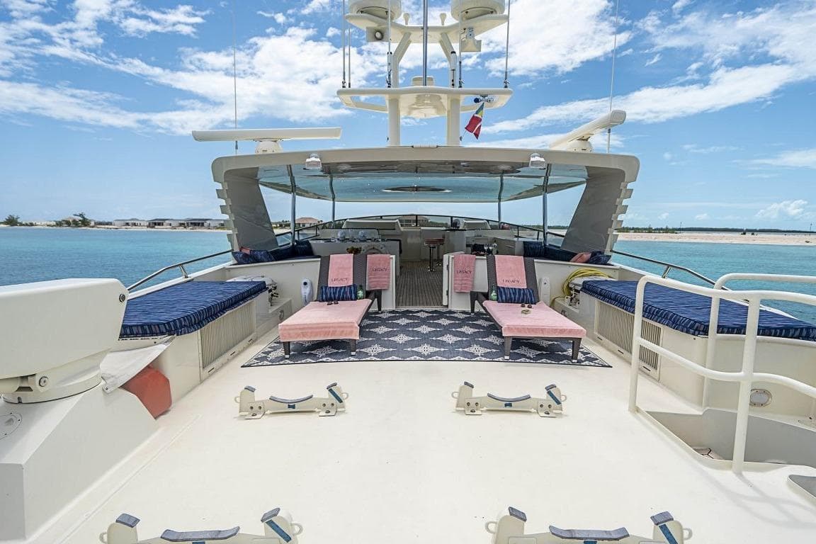 Luxurious 2000 Broward Raised Pilothouse yacht deck with seating, ocean view, and clear skies.