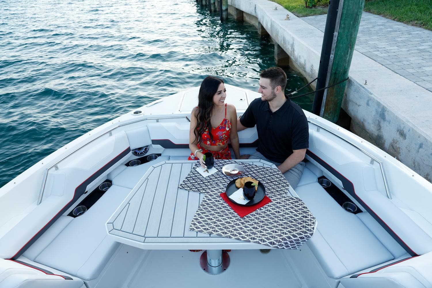Couple dining on a 2023 Formula 387 Center Console Sport boat by the water.