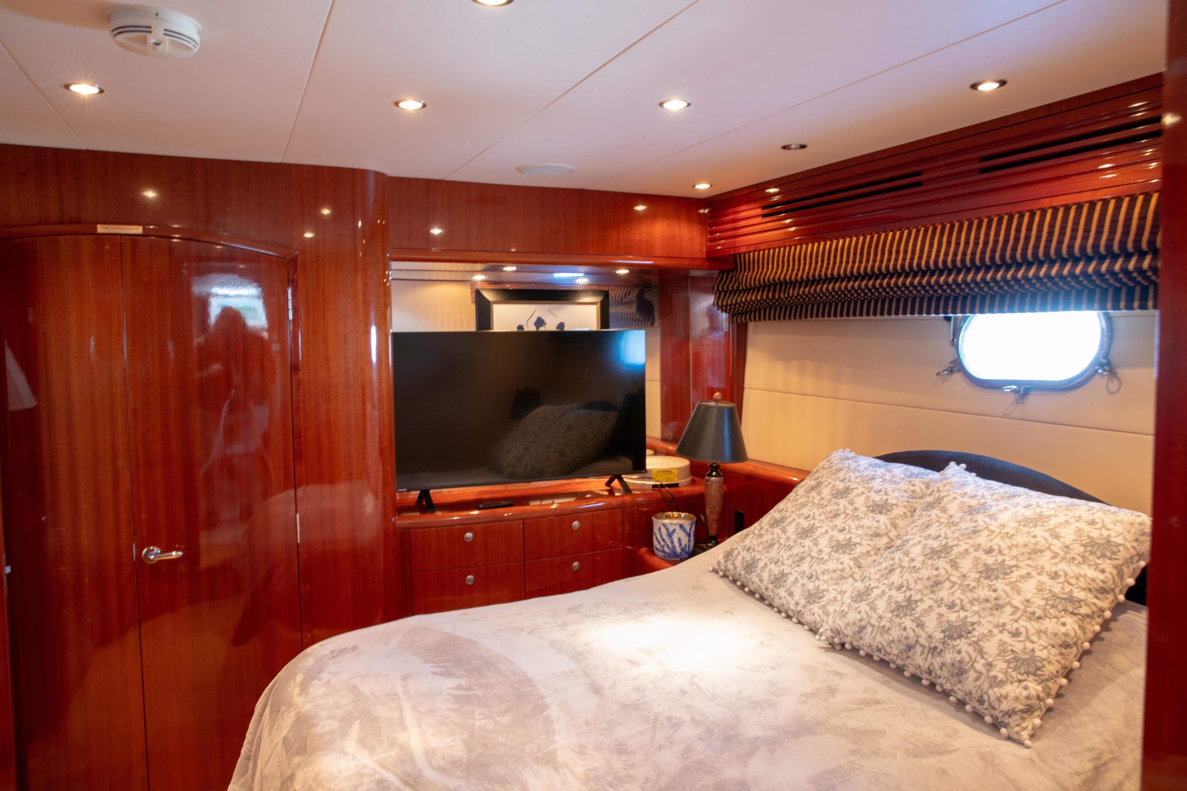 Luxurious bedroom interior of 2002 Hatteras 63 Raised Pilothouse Motor Yacht with elegant wood finish.
