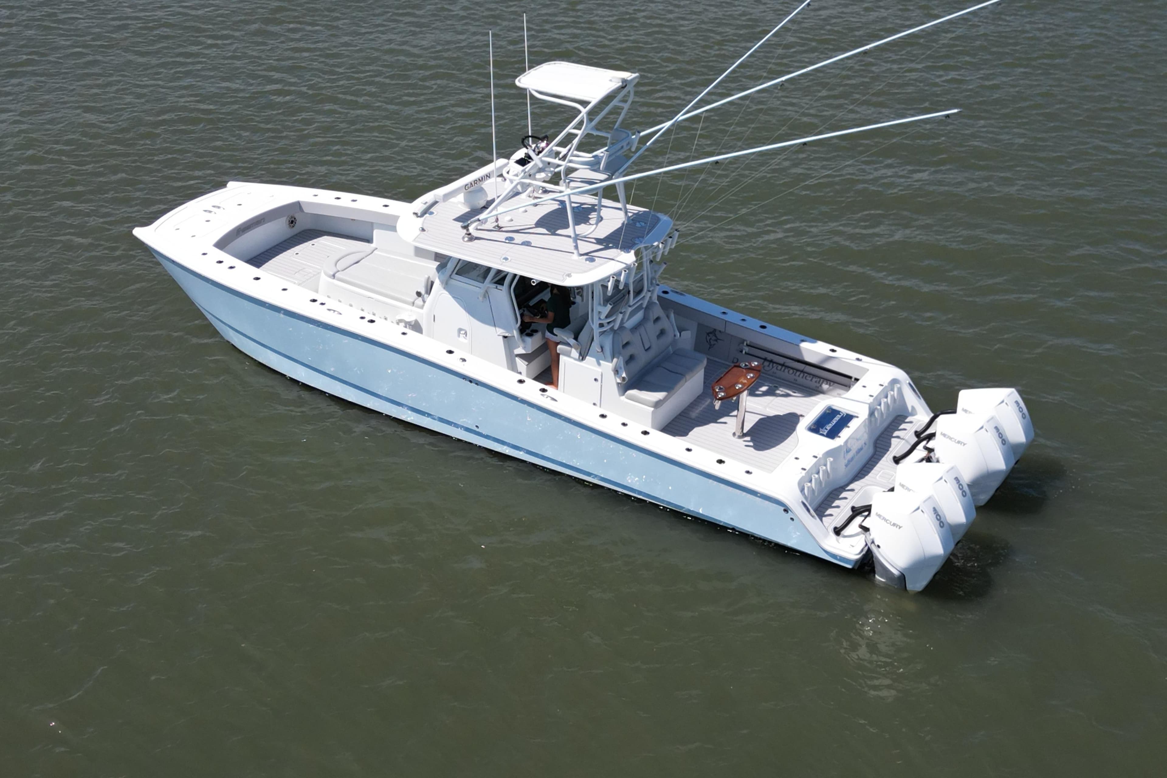 Aerial view of 2021 Freeman 37VH boat with triple outboard engines on water.