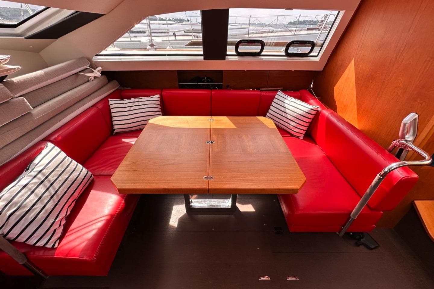 Luxurious interior of 2021 Wauquiez Pilot Saloon 48 with red seating and striped cushions.