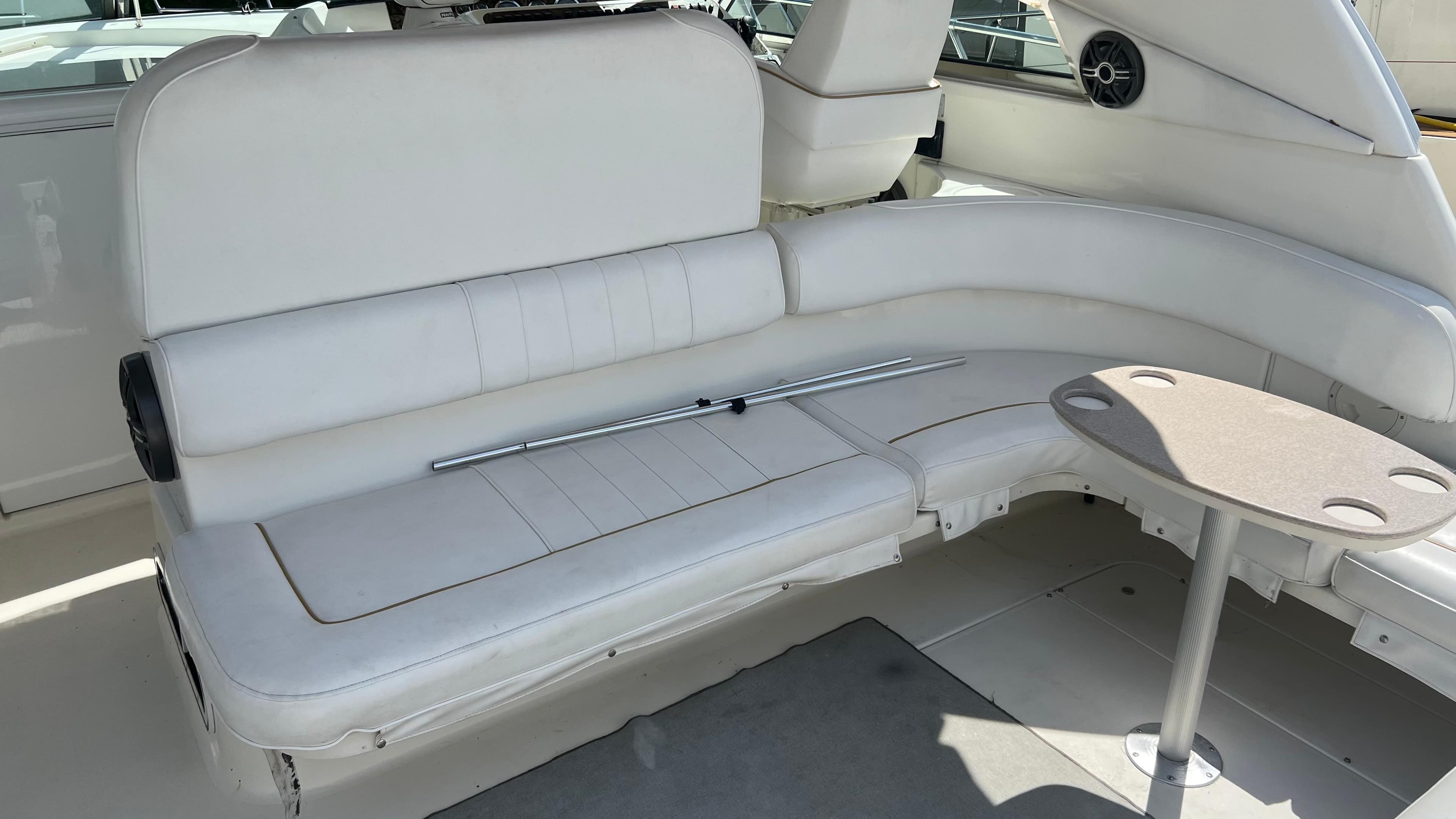 1997 Sea Ray 400 boat interior with white seating and small table.