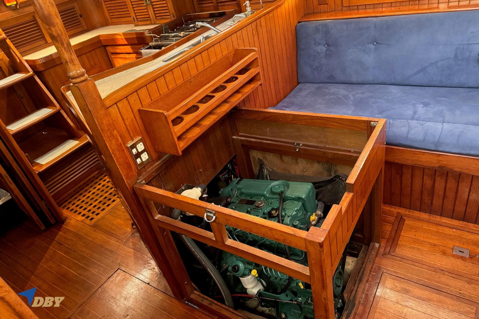 Engine compartment of 1984 Passport 40 sailboat with wooden interior and blue seating.