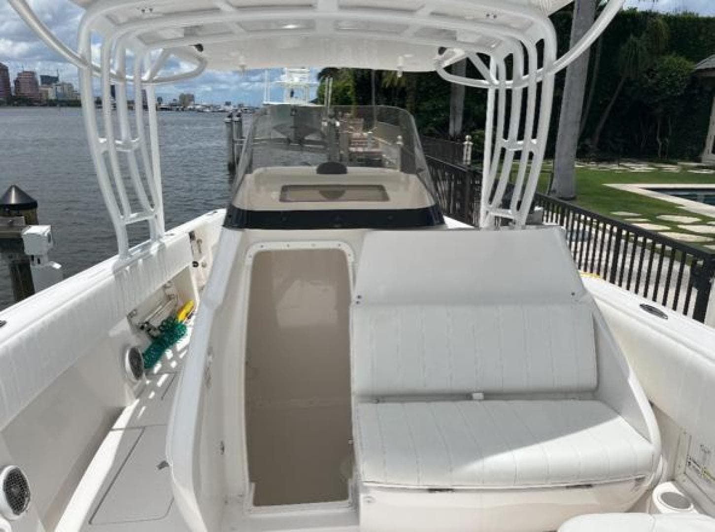 2012 Intrepid 327 boat with white seating, docked by a waterfront.