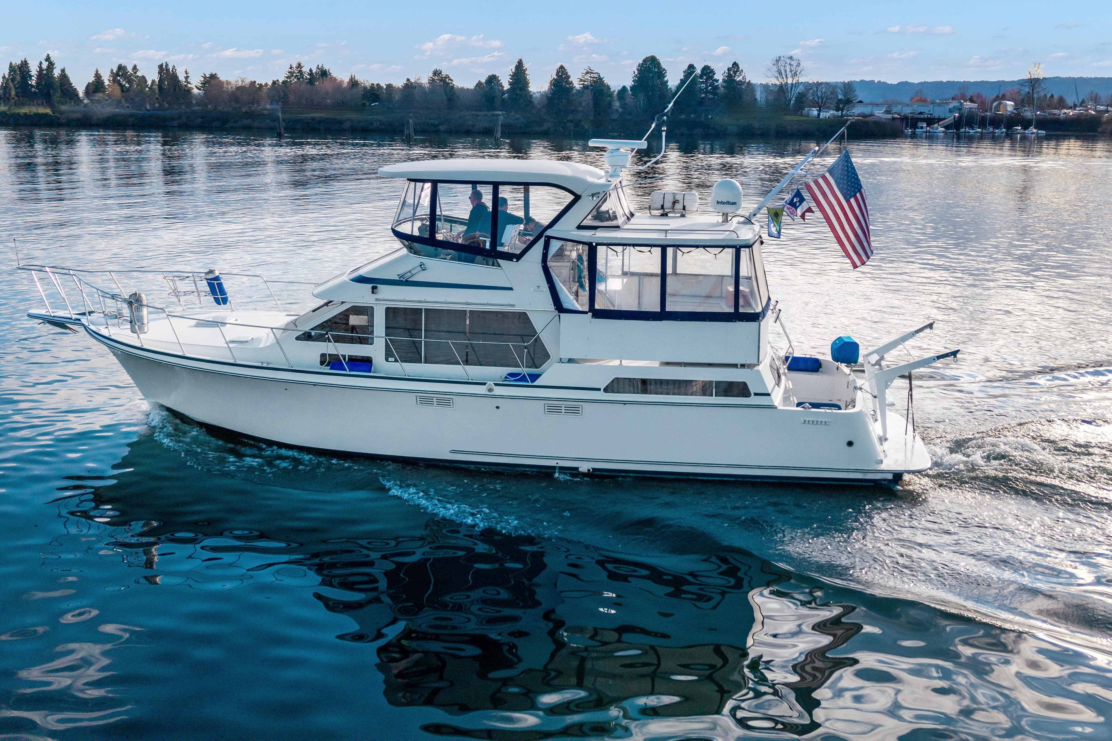 1994 Tollycraft 45 Cockpit Motor Yacht cruising on calm waters with American flag.