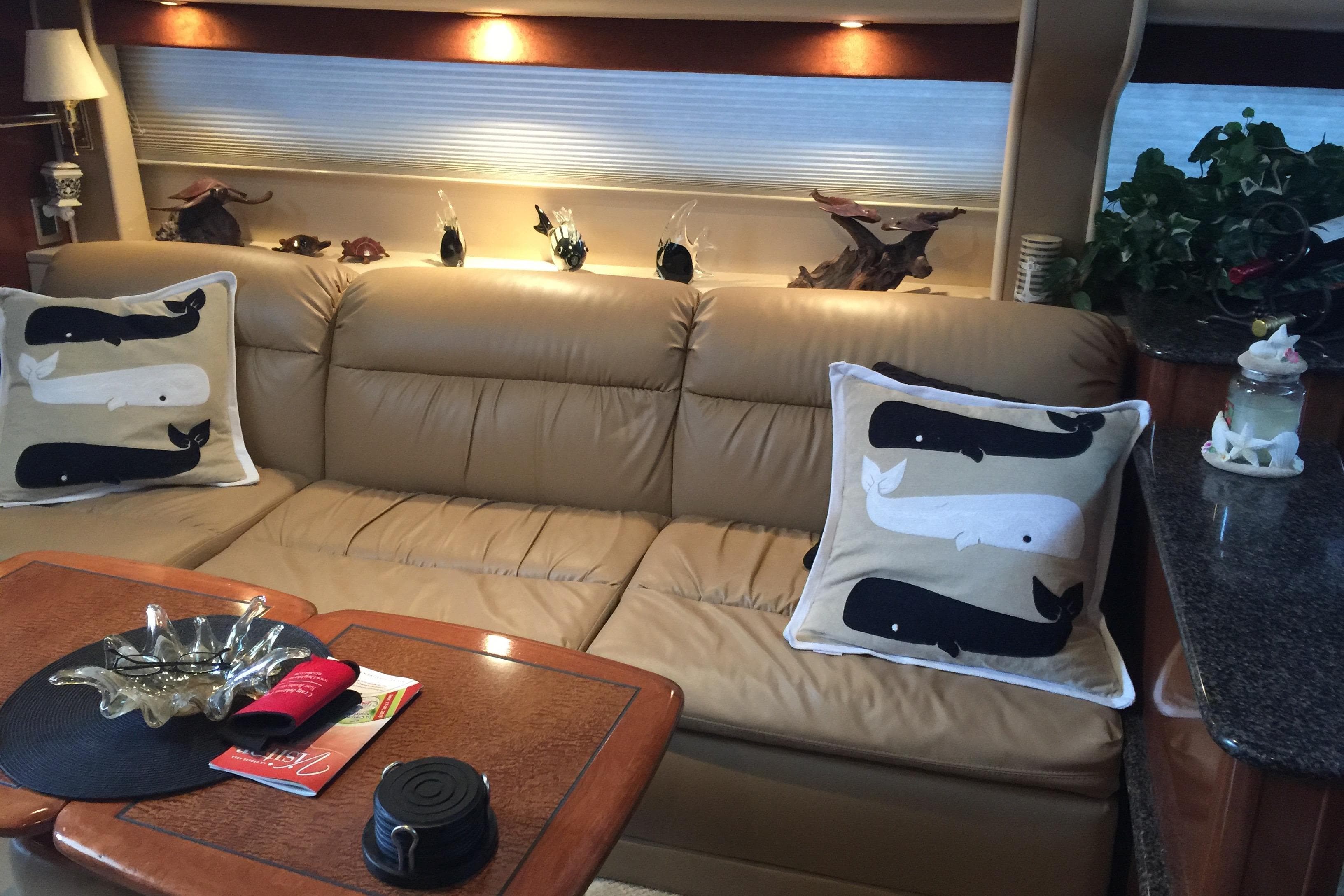 Luxurious 2006 Meridian 408 Motoryacht interior with beige leather sofa and decorative whale pillows.