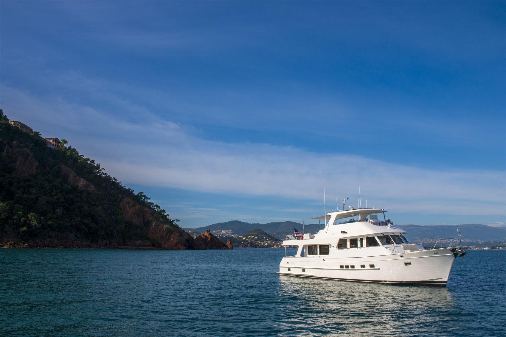 2027 Outer Reef Yachts 640 Azure Motoryacht on serene coastal waters.