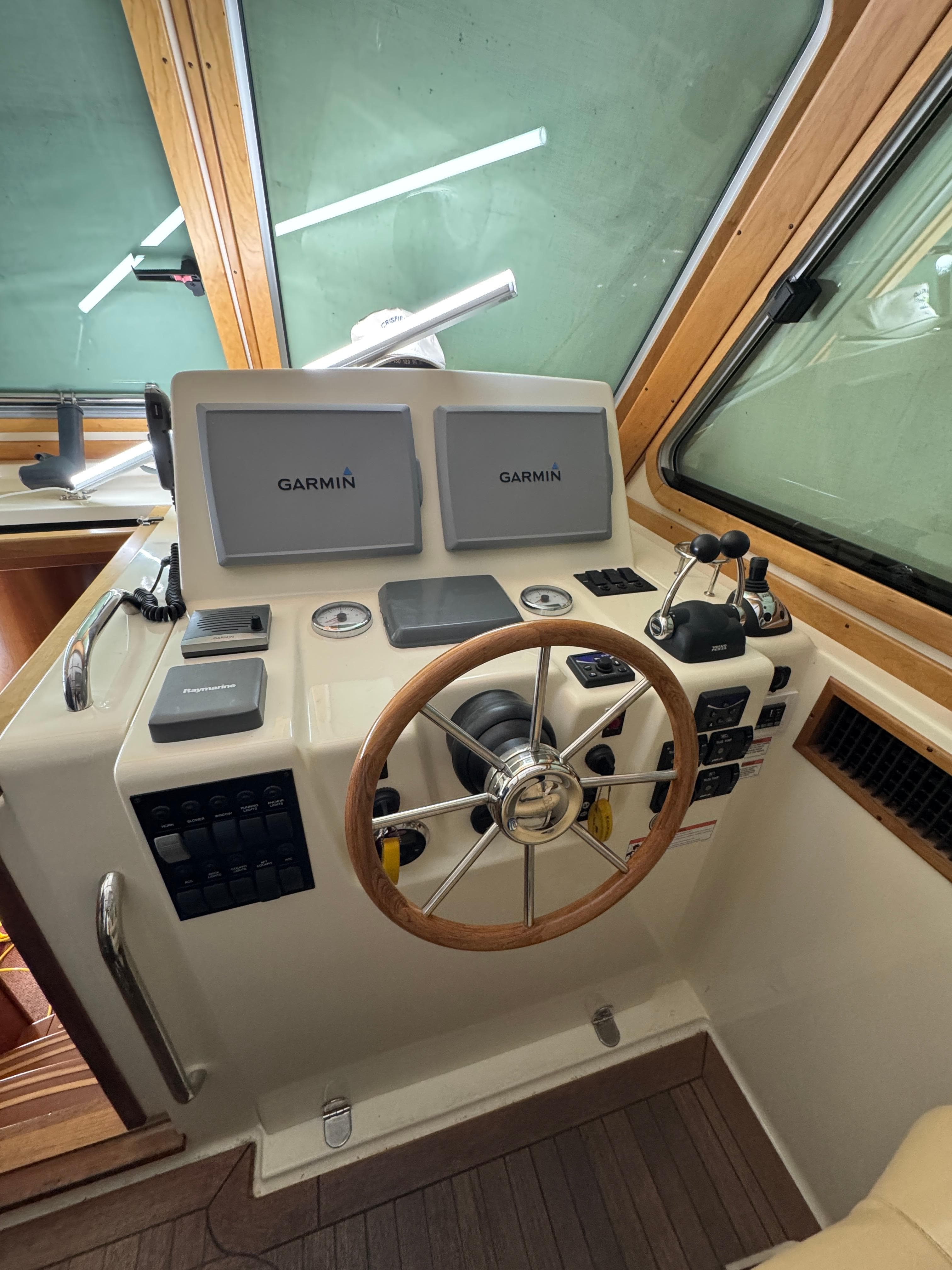 2008 Sabre 38 Hardtop Express helm with Garmin navigation displays and wooden steering wheel.