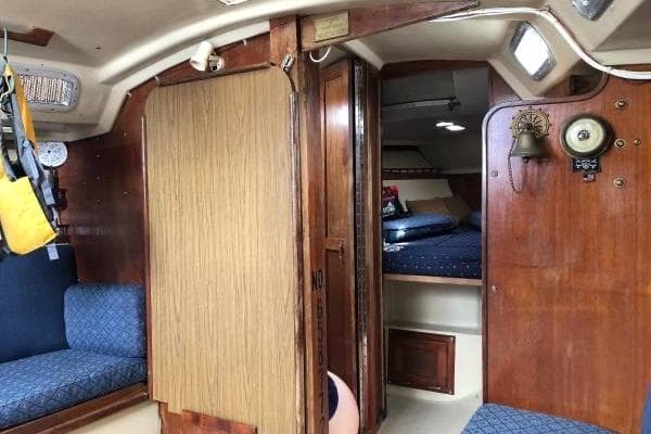 Interior of a 1981 Catalina 30 sailboat with wood paneling and blue seating.