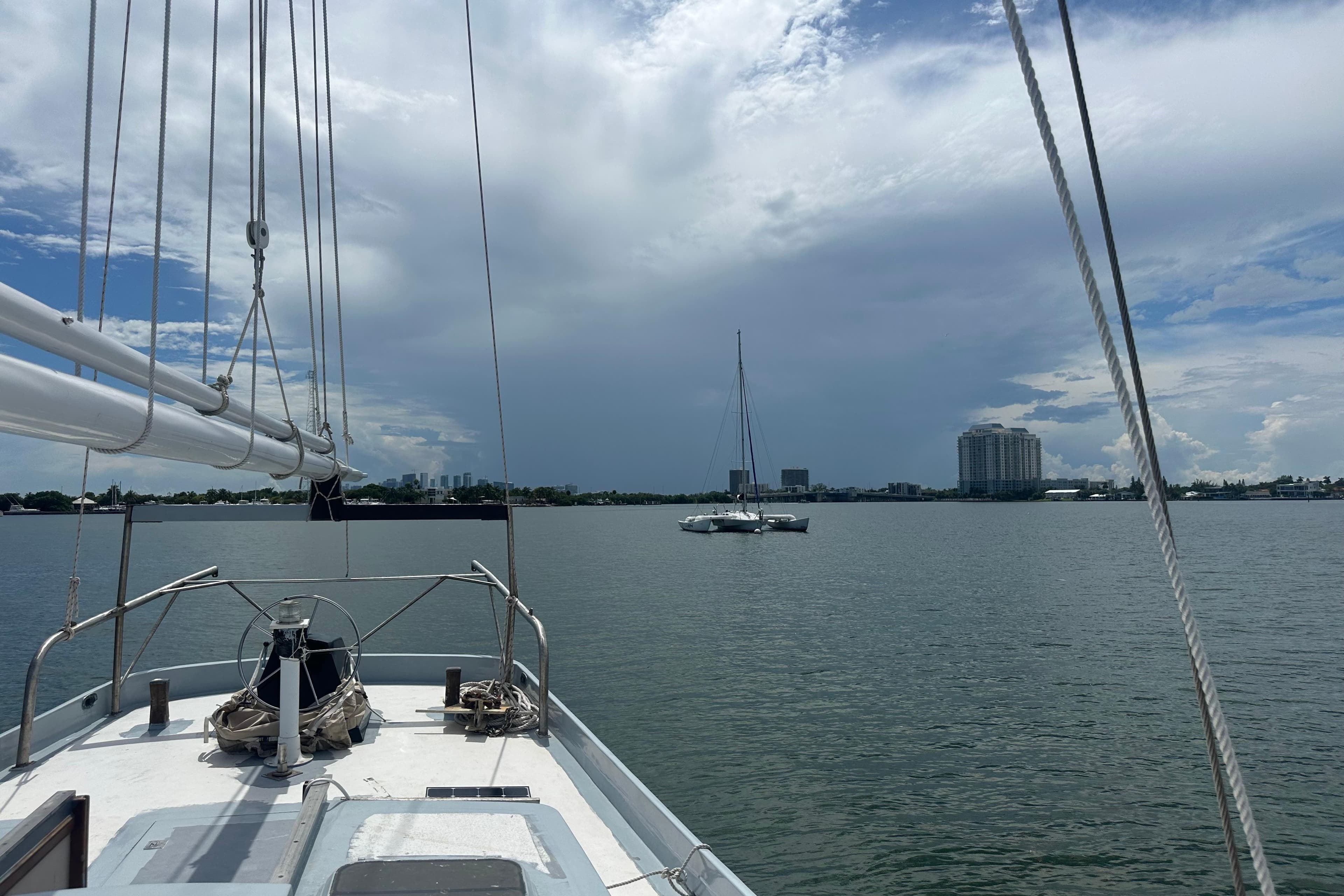 Sailing on Pilot Schooner Leopard, 1994, with city skyline and cloudy sky in background.