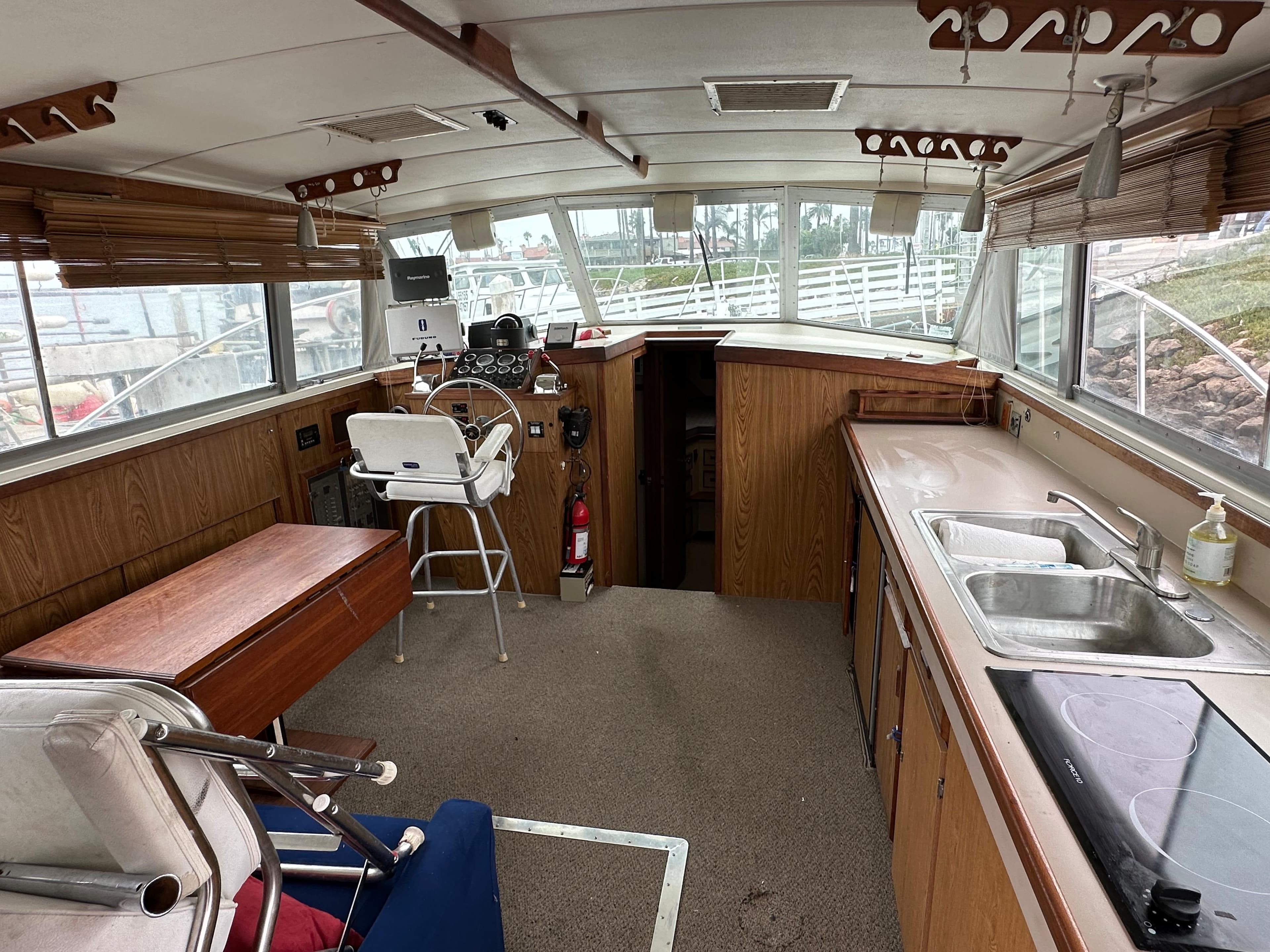 Interior of a 1981 Bertram 38III Convertible boat with helm, seating, and kitchenette.