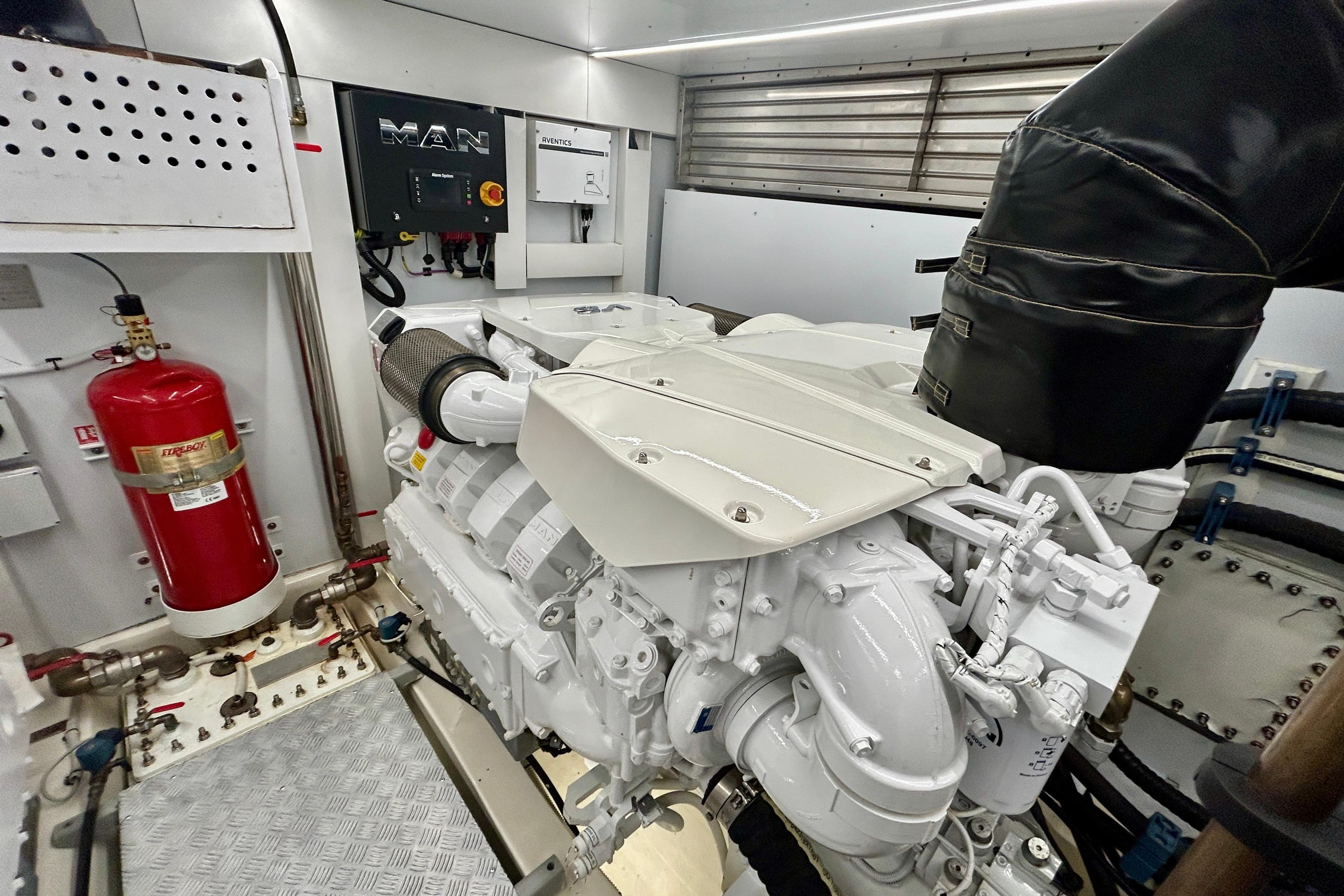 Engine room of 2024 Aicon Vivere 66 yacht featuring MAN engine and fire extinguisher system.