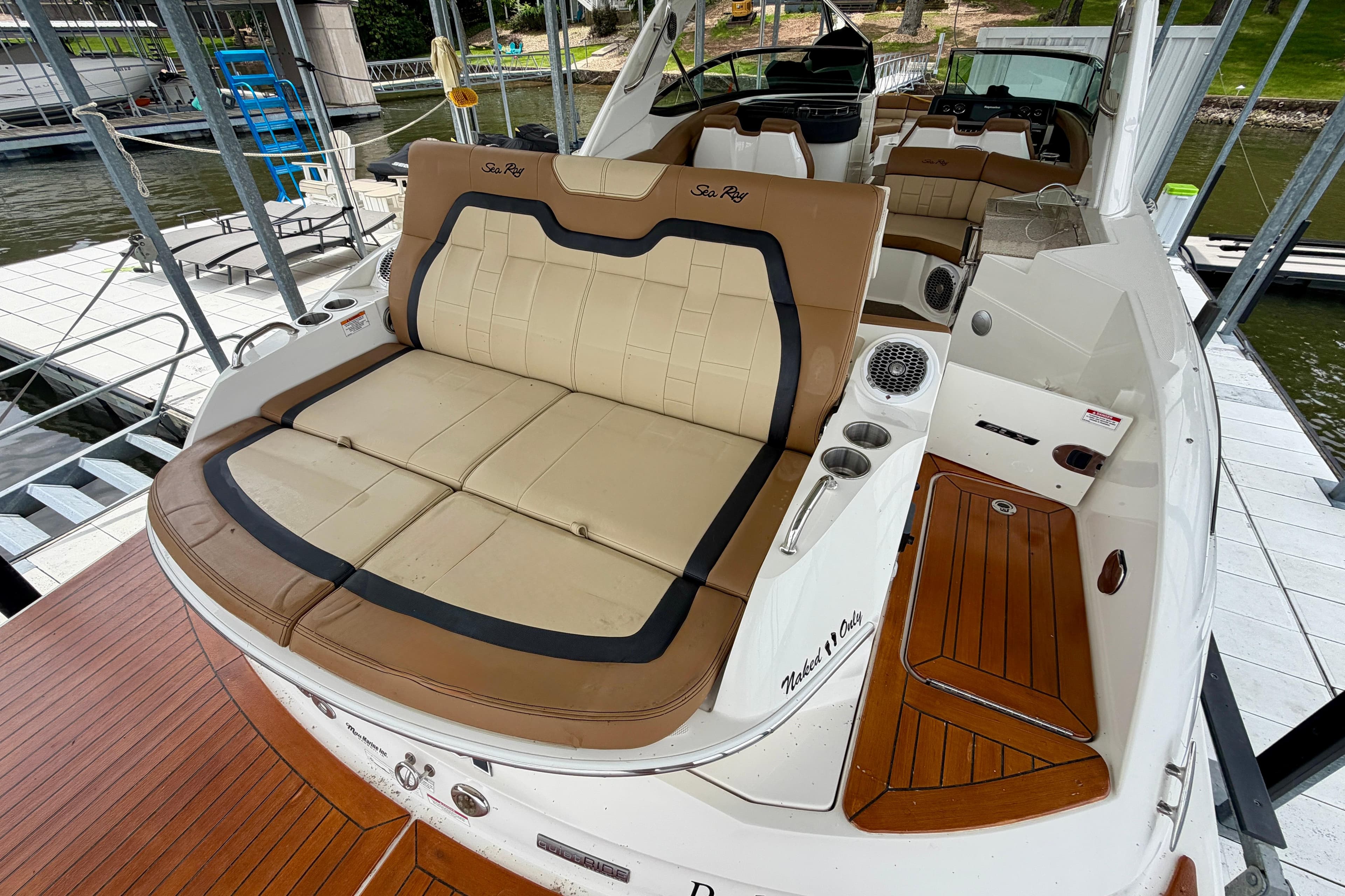 2015 Sea Ray SLX 350 boat with luxurious seating and teak flooring at a dock.