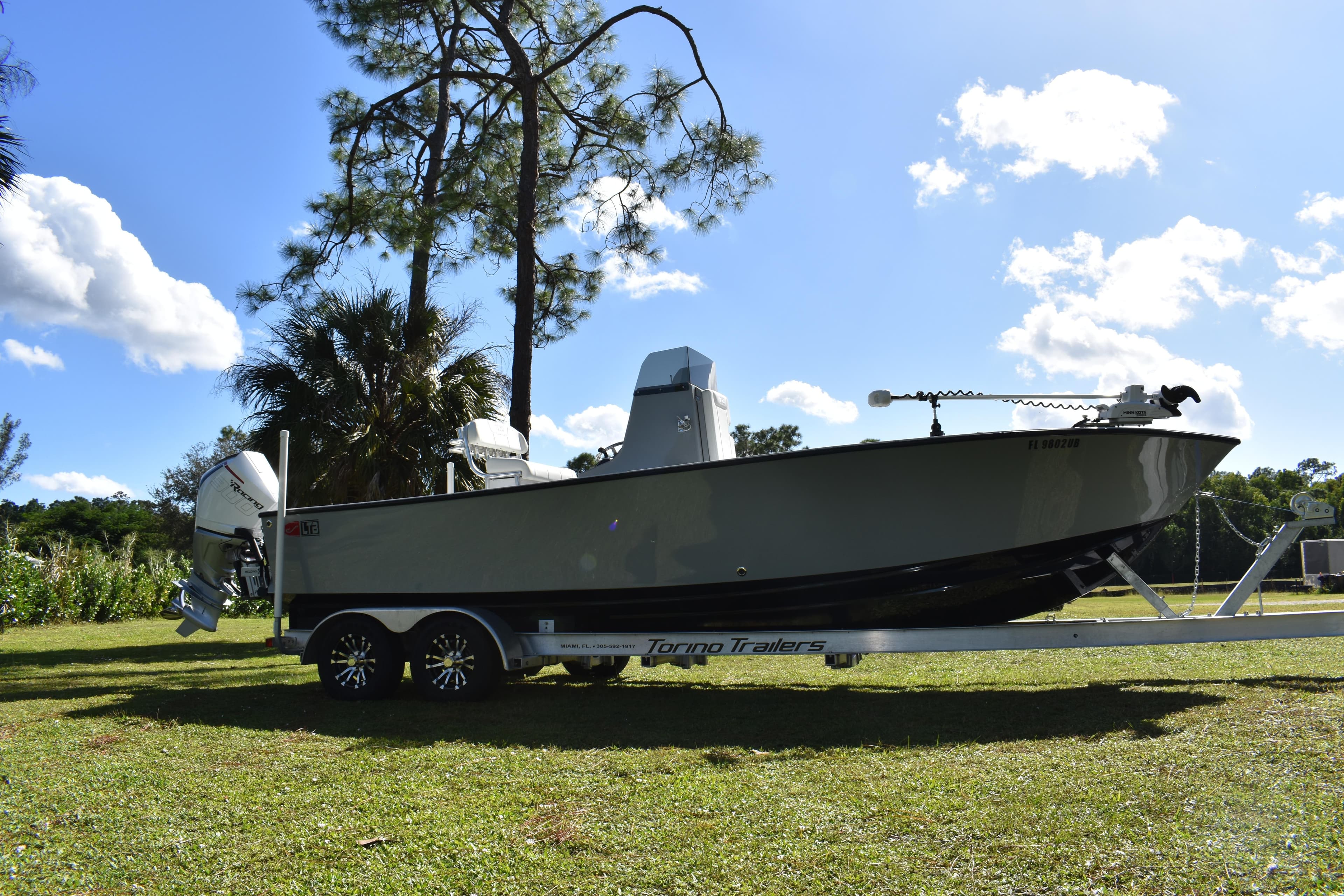2025 Latitude Tournament Boats 25 on trailer, parked on grass under clear sky.