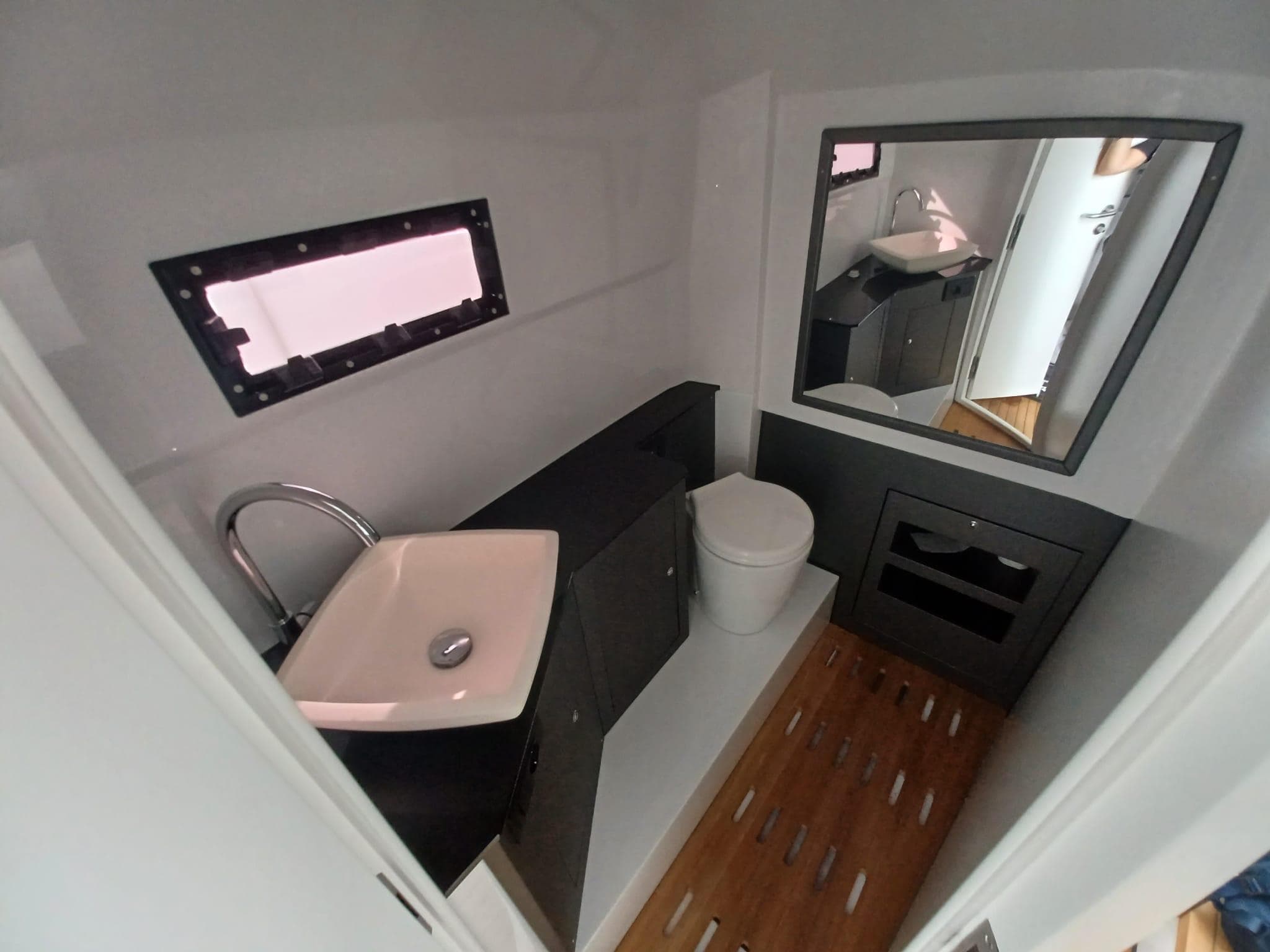 Modern bathroom interior in 2025 Pirelli PIRELLI 42 yacht, featuring sink, toilet, and mirror.