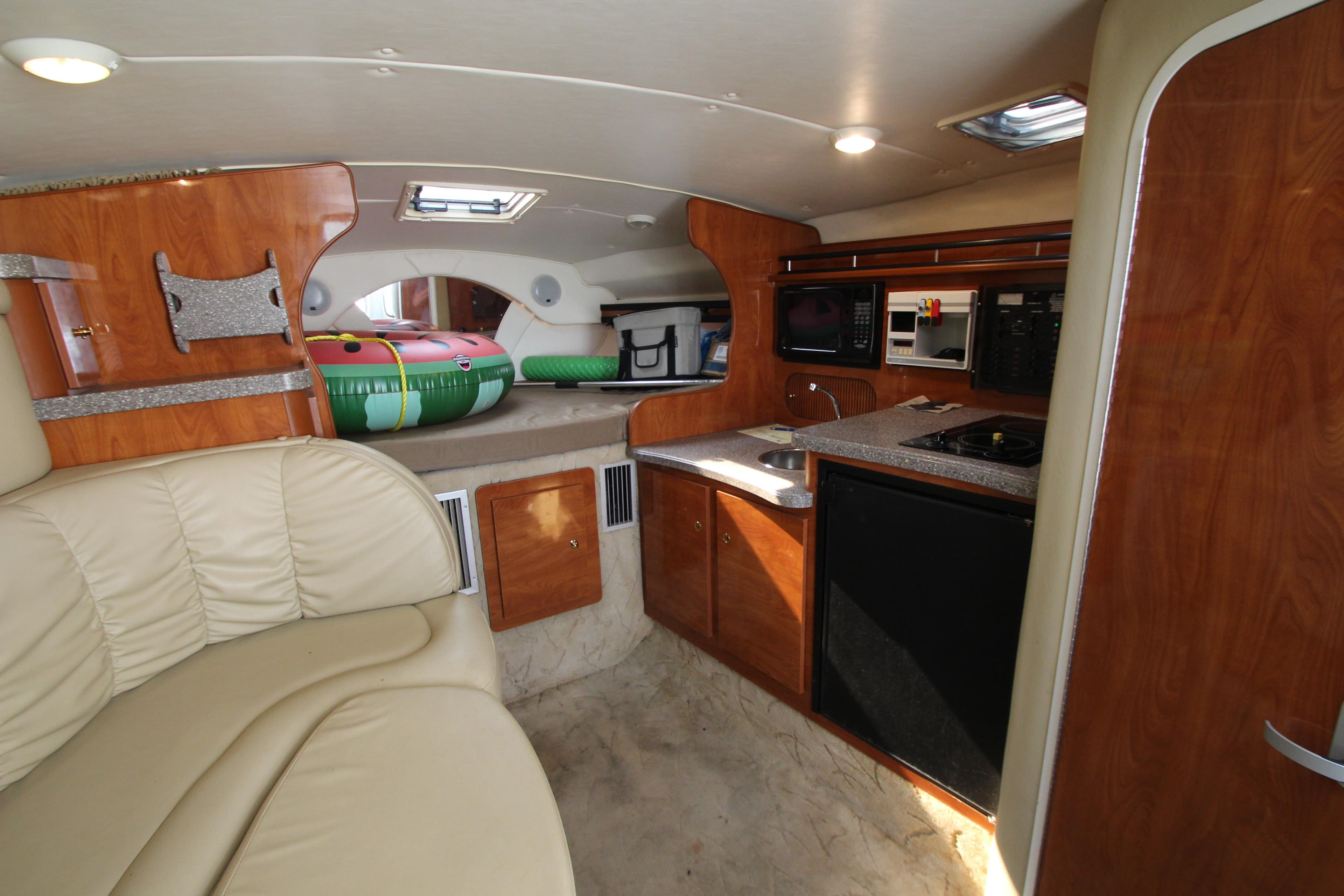 Interior of 2005 Rinker 312 Fiesta Vee boat with kitchenette and seating area.