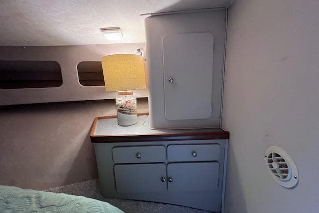 1987 Trojan 10.8 Meter Sedan interior with cabinet, lamp, and cozy decor.