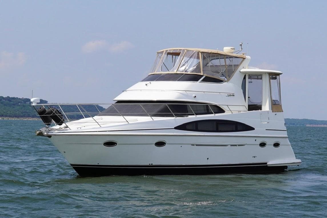 2003 Carver 396 Motor Yacht cruising on open water under clear skies.