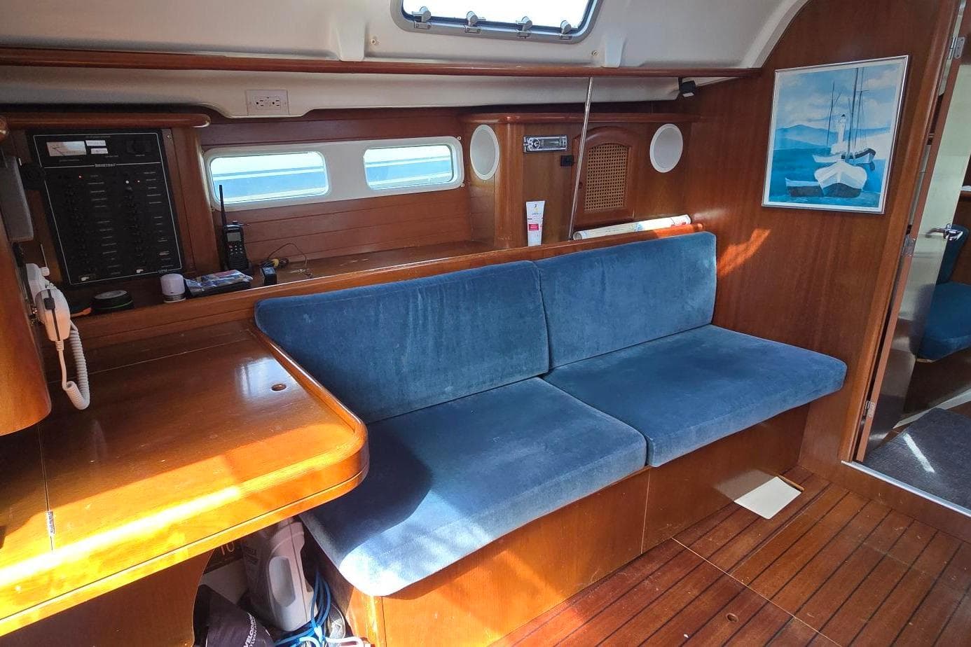 Interior of 1998 Beneteau Oceanis 411 sailboat with blue seating and wooden finishes.