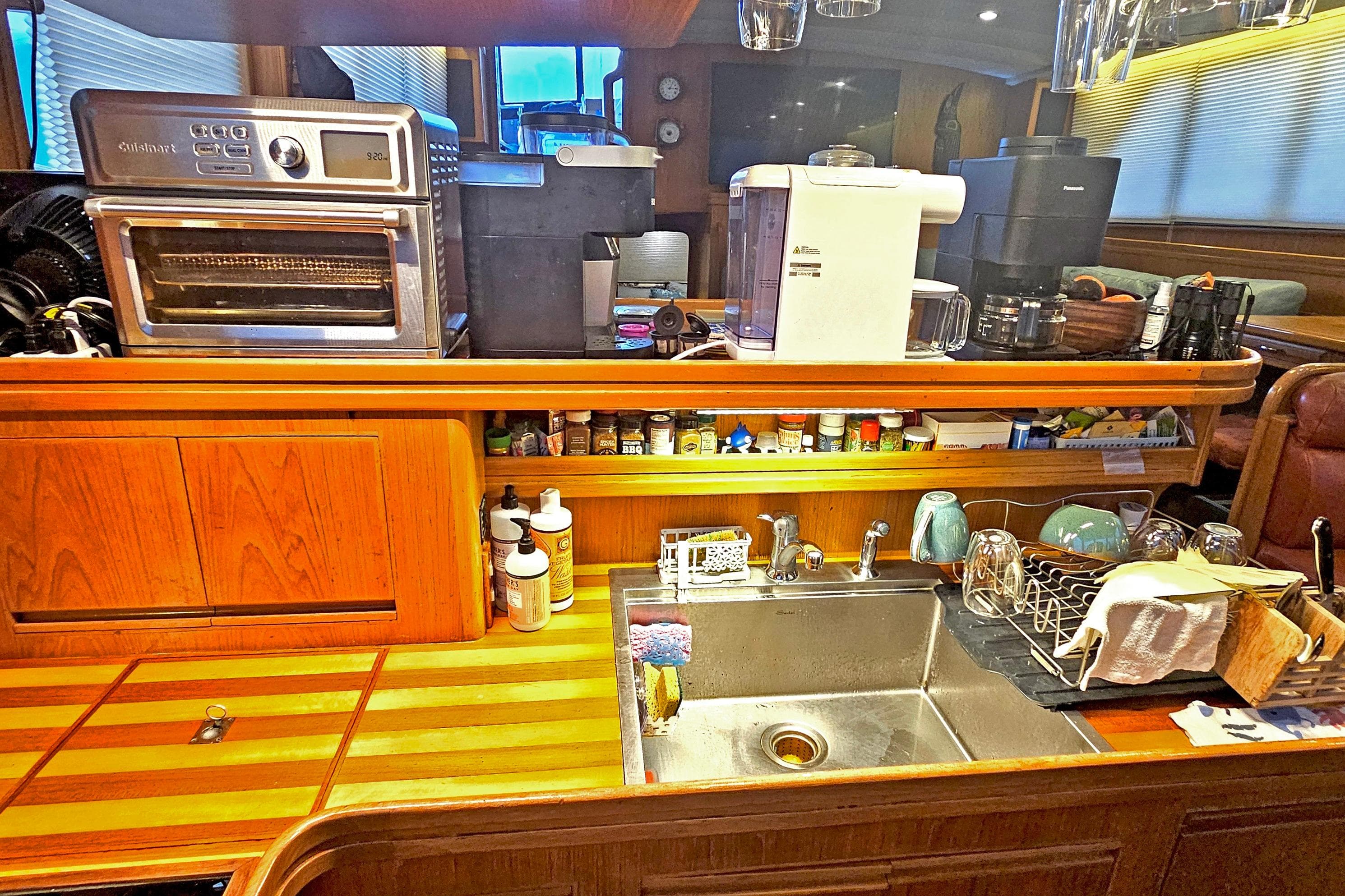 Galley kitchen in 1993 Symbol 55 Yachtfisher with appliances and wooden cabinetry.