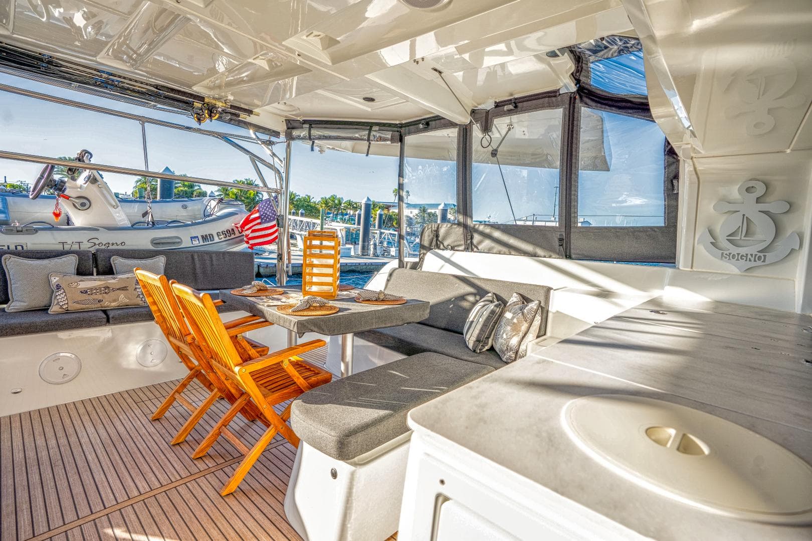 Luxurious 2024 Lagoon 46 yacht interior with seating, table, and scenic marina view.