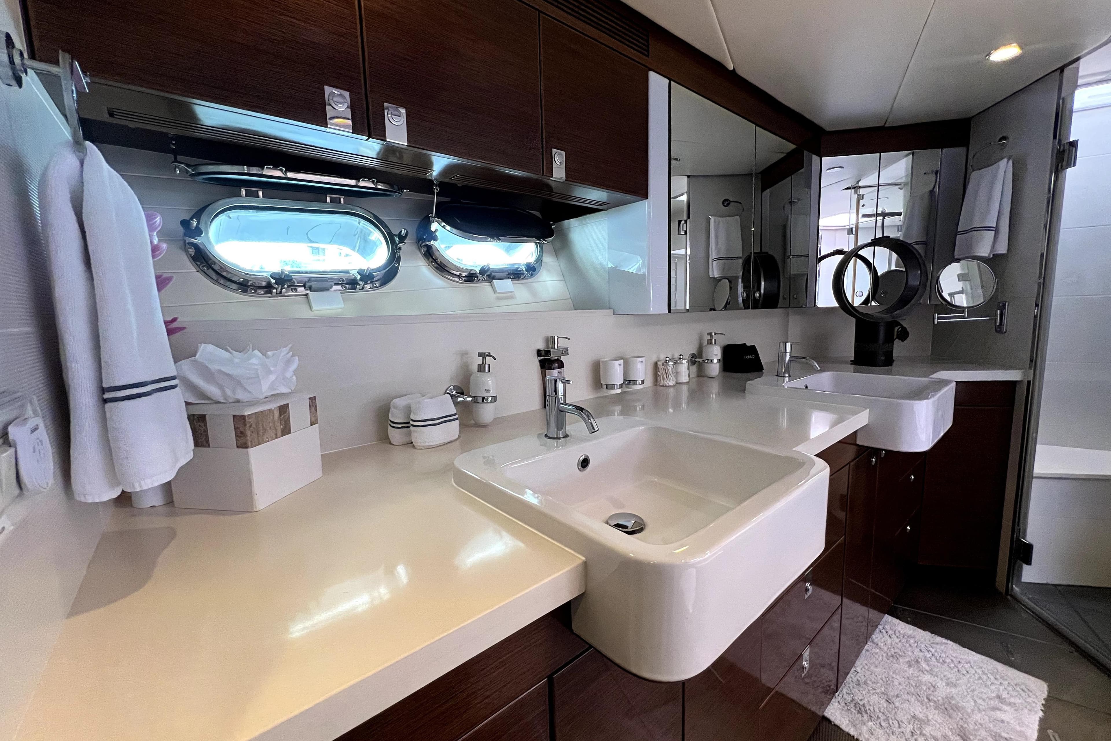 Luxurious bathroom interior of 2009 Nordhavn N78 yacht with modern fixtures and porthole windows.