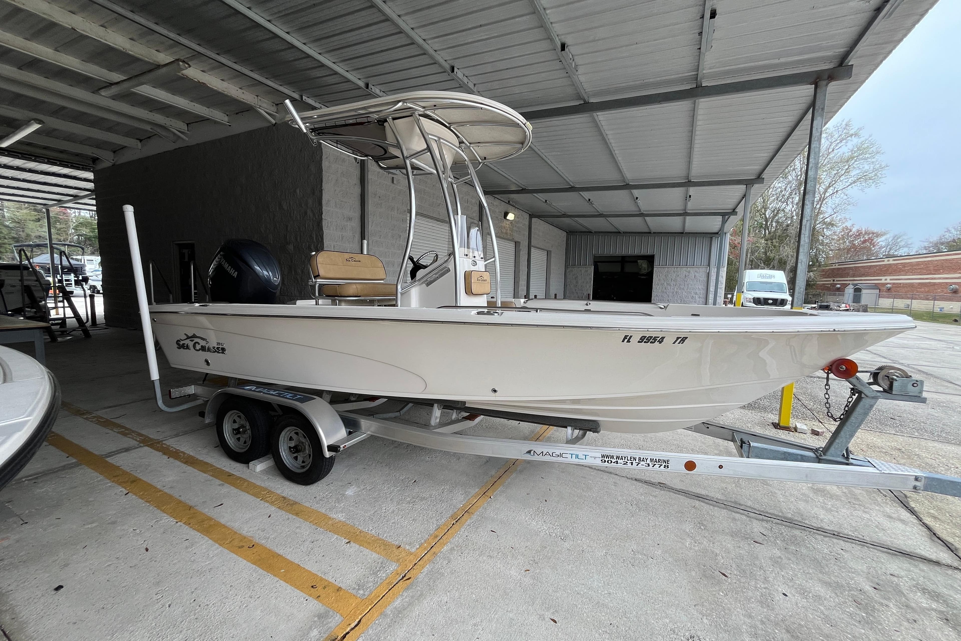 2024 Sea Chaser 21 LX boat on trailer under a metal canopy.
