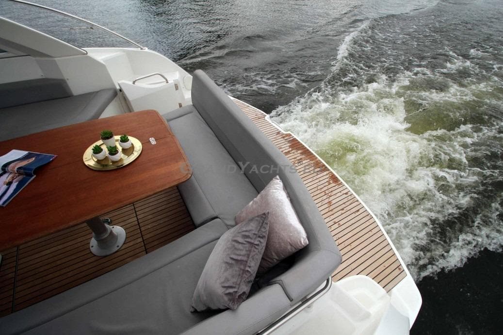 2011 Beneteau Gran Turismo 38 yacht with elegant deck seating and table, cruising on water.