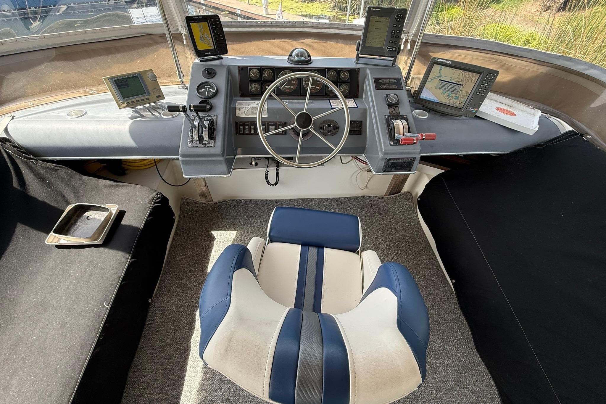1991 Bayliner 4387 Motoryacht flybridge helm with navigation equipment and captain's chair.