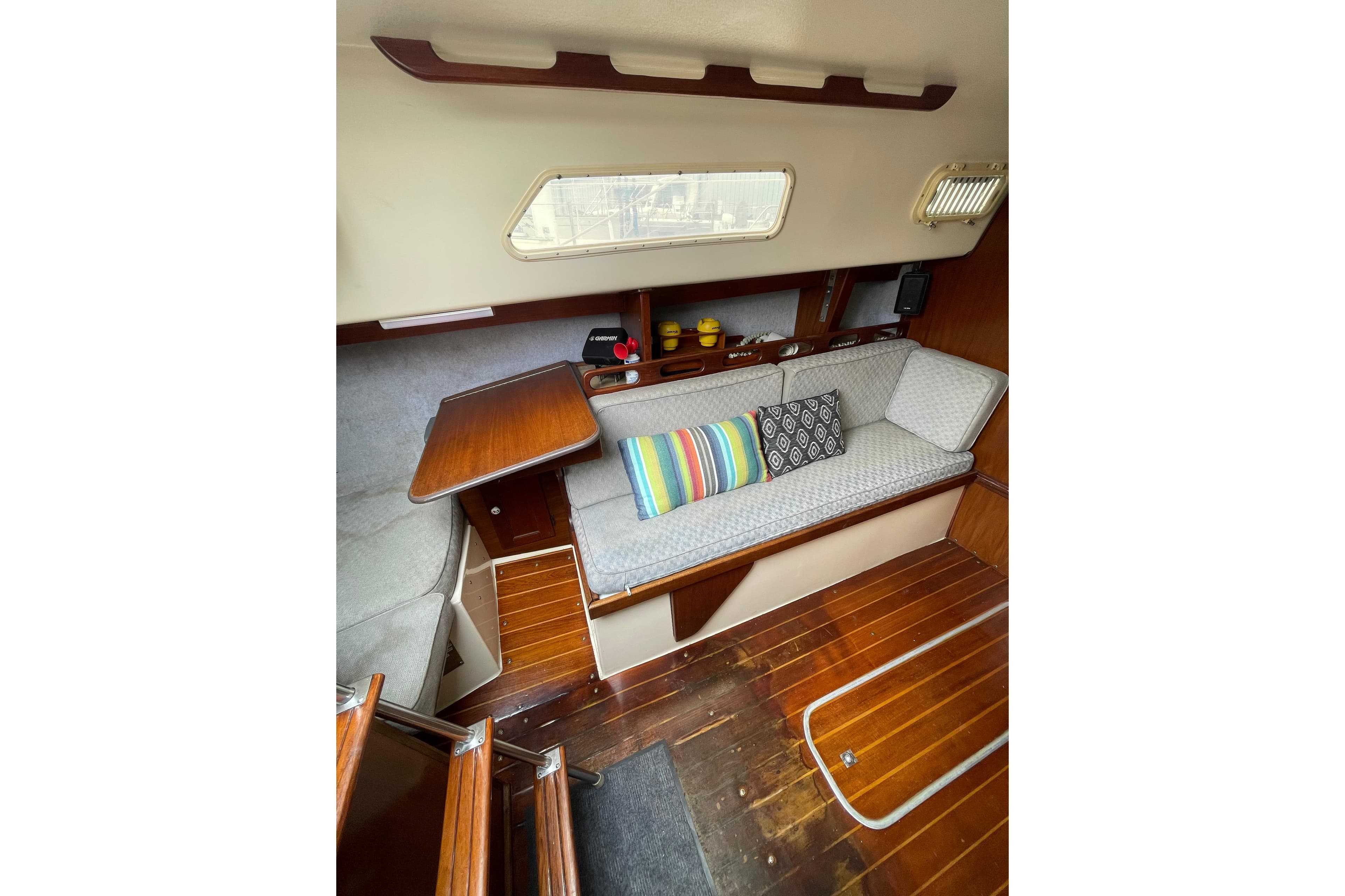 Interior of a 1978 Hunter 30 sailboat with cozy seating and colorful cushions.