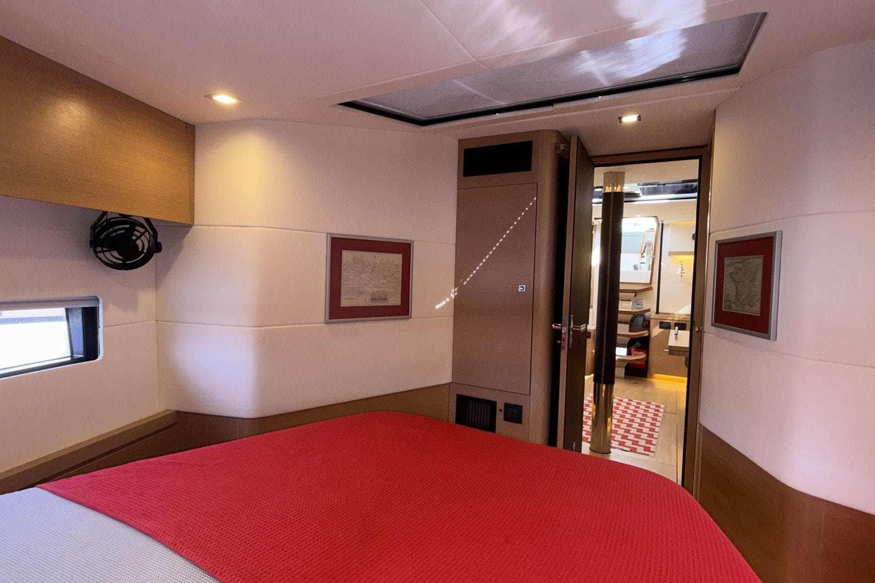 Luxurious cabin interior of 2019 Amel 50 yacht with red bedding and modern decor.