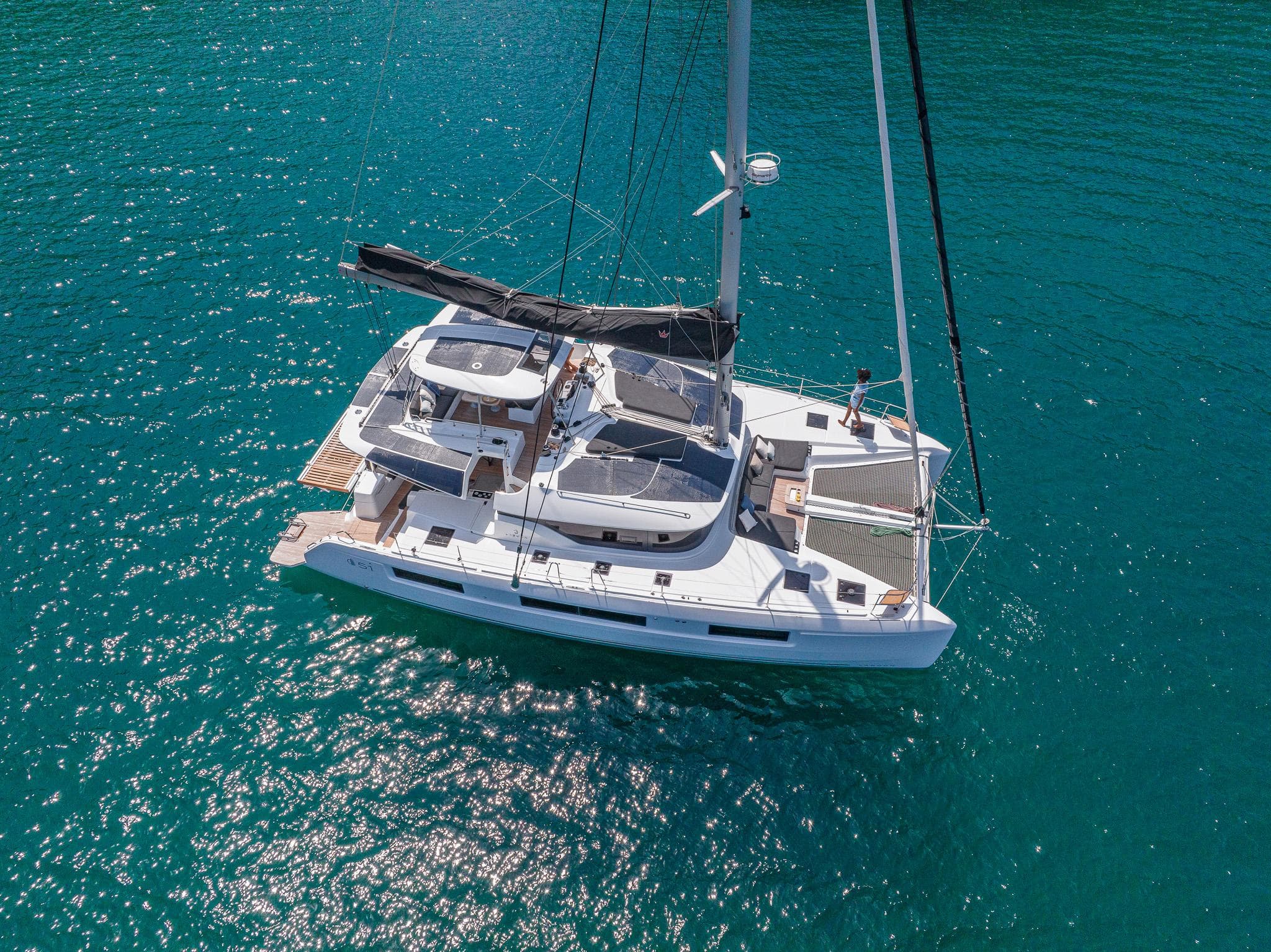 2025 Lagoon 51 ICONIC catamaran sailing on clear blue water.