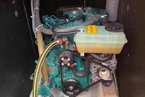 Engine compartment of a 2023 Dufour 37 sailboat, showcasing mechanical components and hoses.