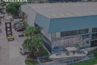 Aerial view of a 2018 Brig E 480 boat displayed outside a blue-roofed building.