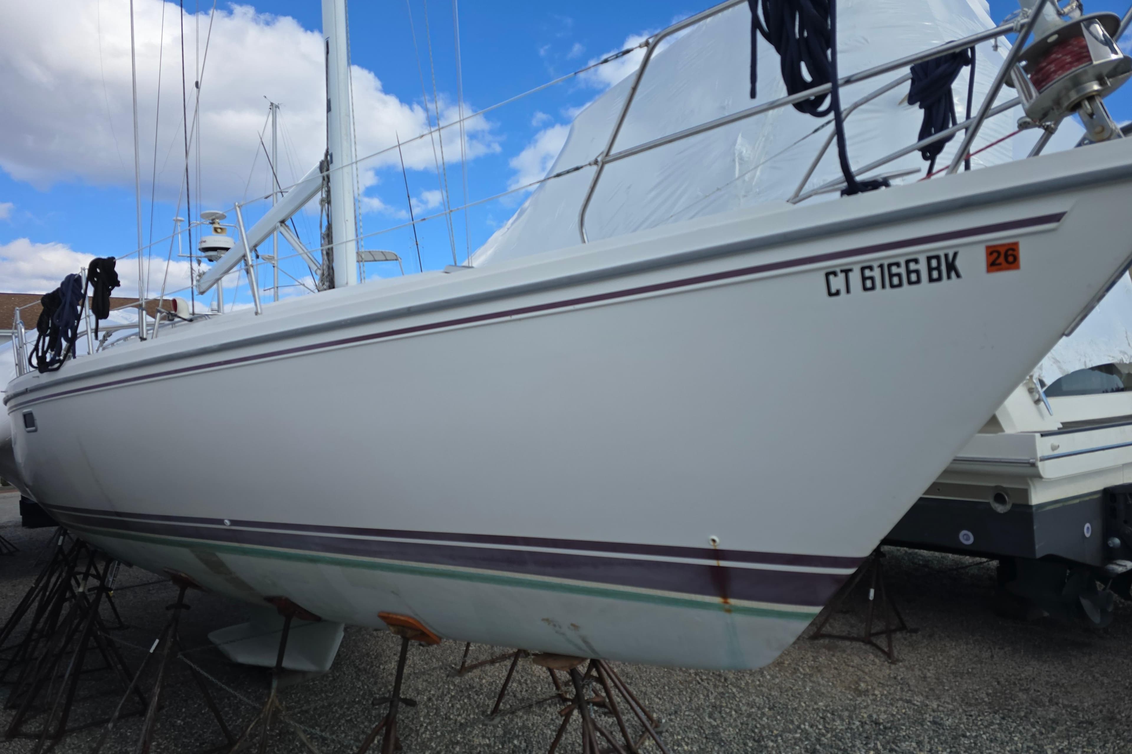 1993 Catalina 42 sailboat on stands, white hull, clear sky background.