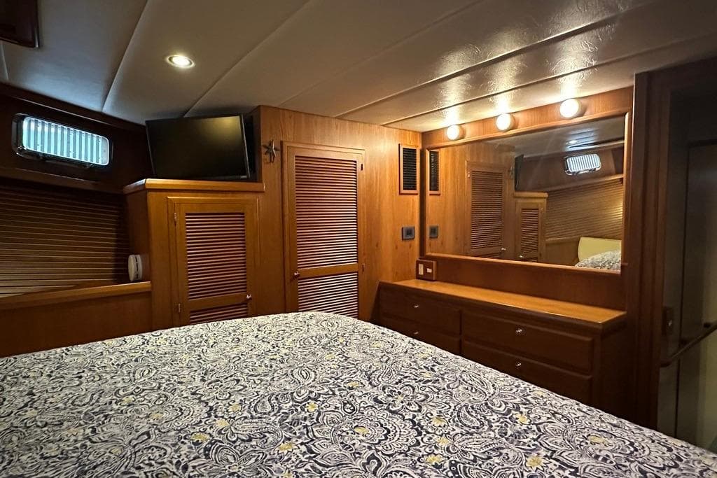 Luxurious 2011 Kadey-Krogen 48 AE yacht bedroom with wood paneling and elegant decor.