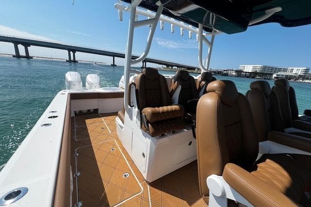 2024 Invincible 46 Catamaran with brown seating, on water near a bridge.