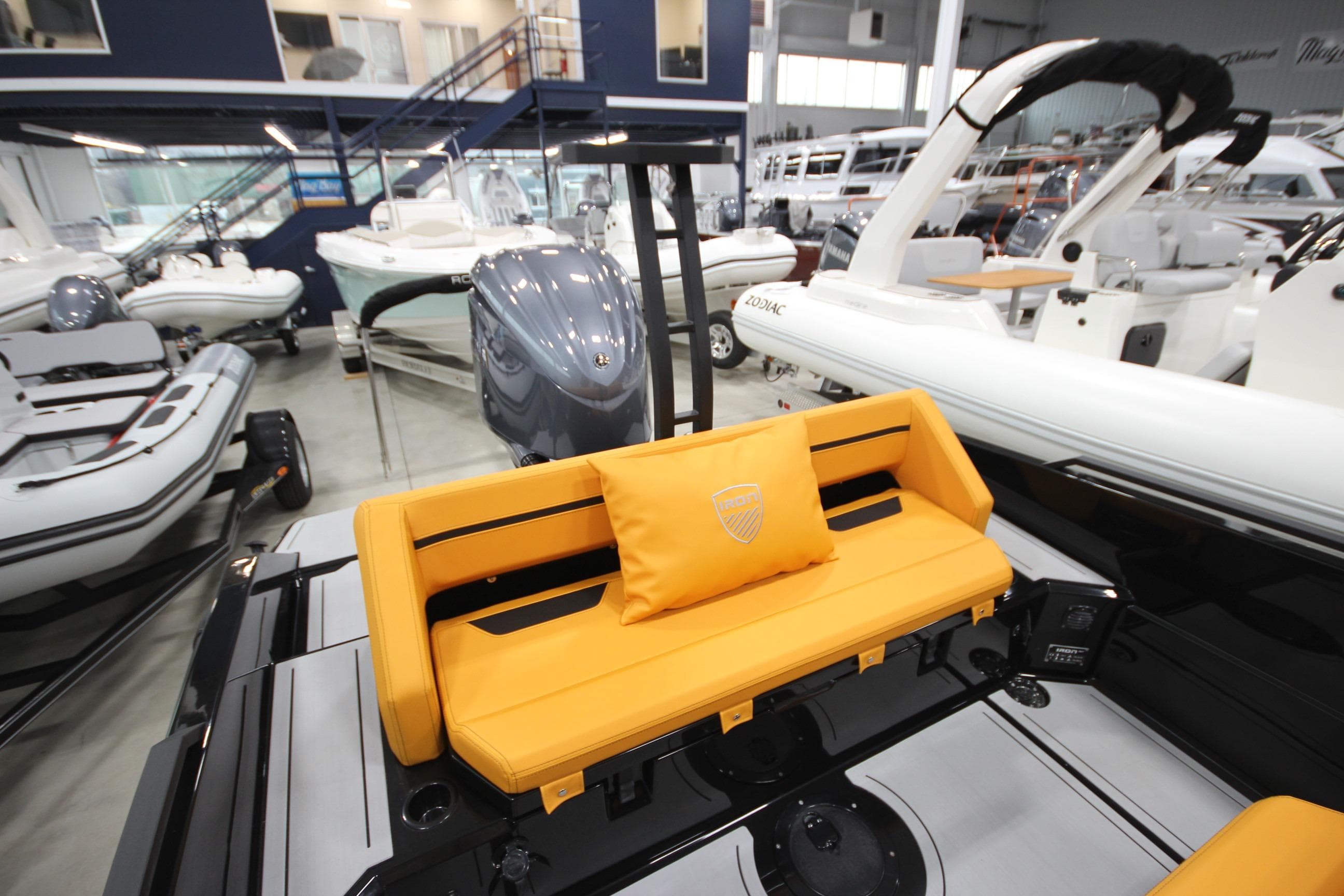 Showroom display of Iron 767 boat, featuring vibrant orange seating and sleek design, 2026 model.