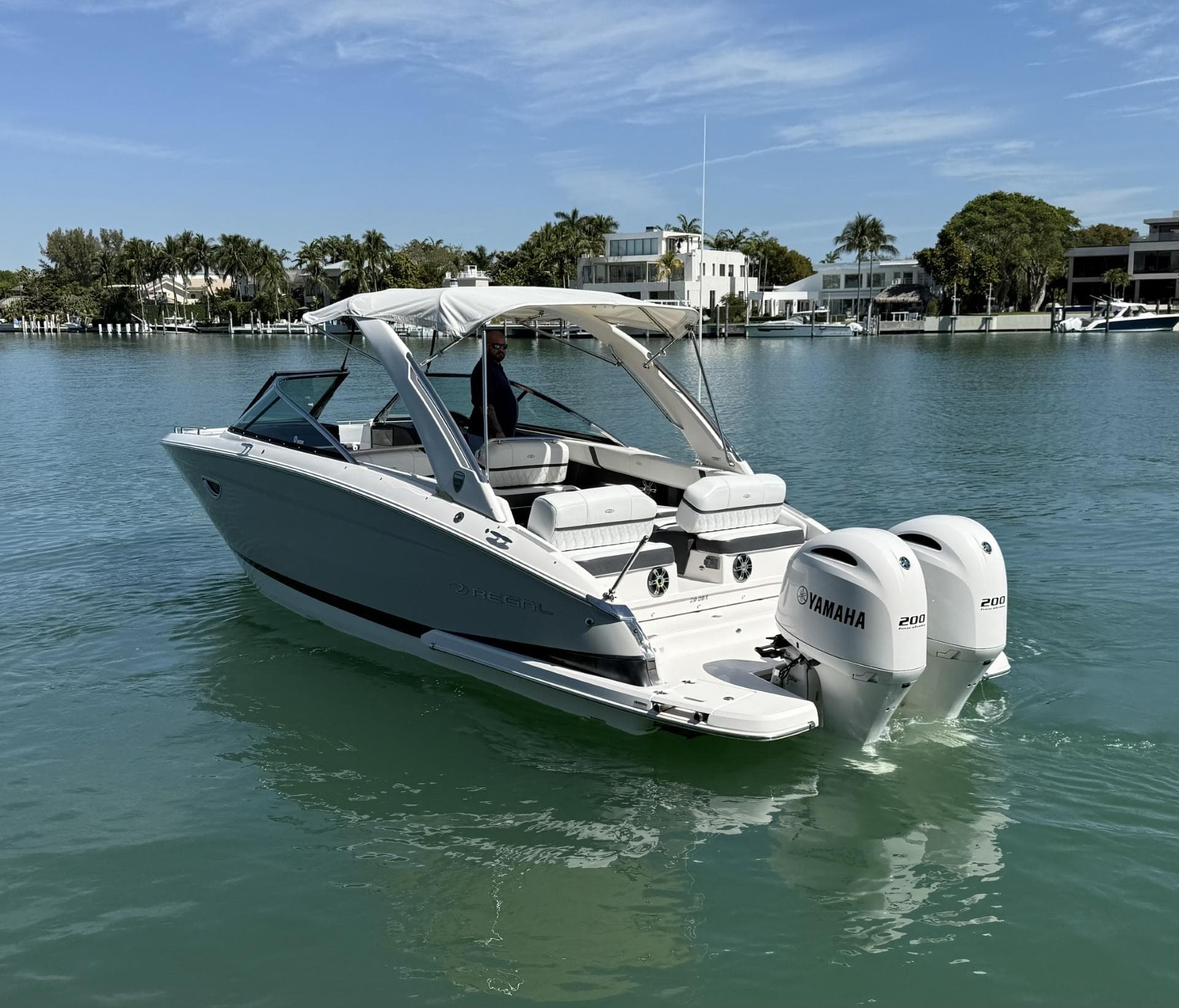 2019 Regal 29 OBX boat with twin Yamaha engines on a calm waterway.