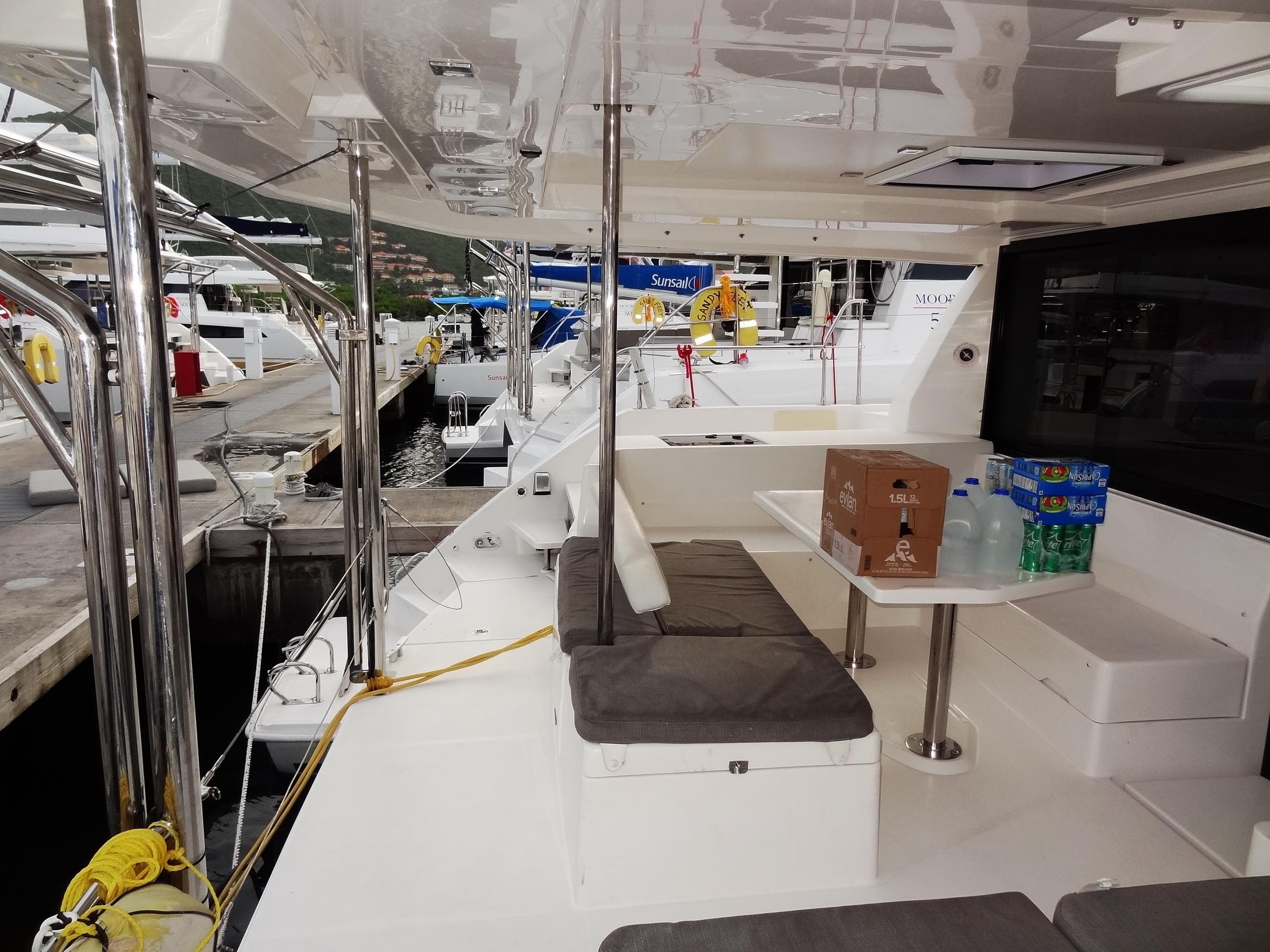 Leopard 40 catamaran 2020 model docked, featuring outdoor seating and table with drinks.