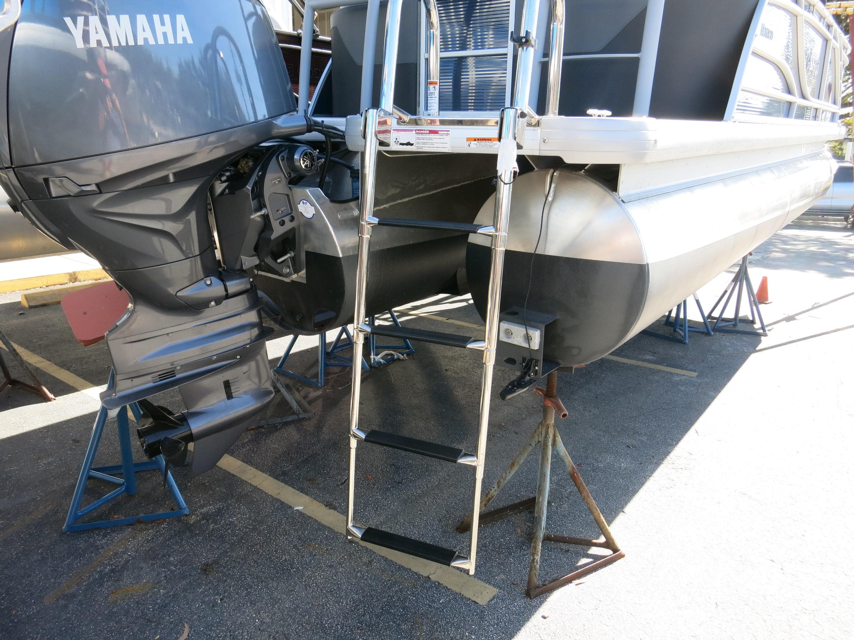 2024 Godfrey Monaco 235SD pontoon boat with Yamaha outboard motor and boarding ladder.